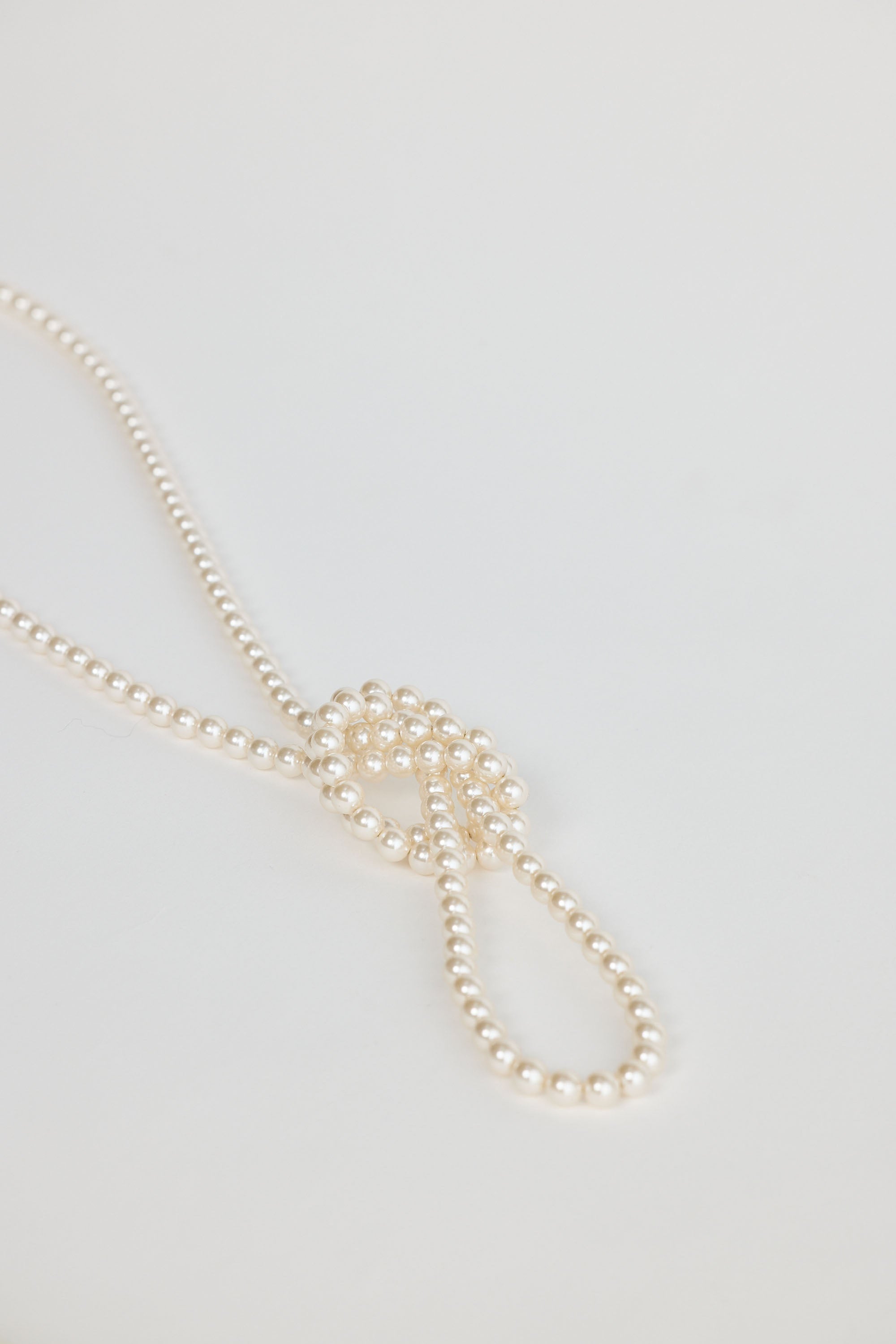 Pearl necklace on a light gray background