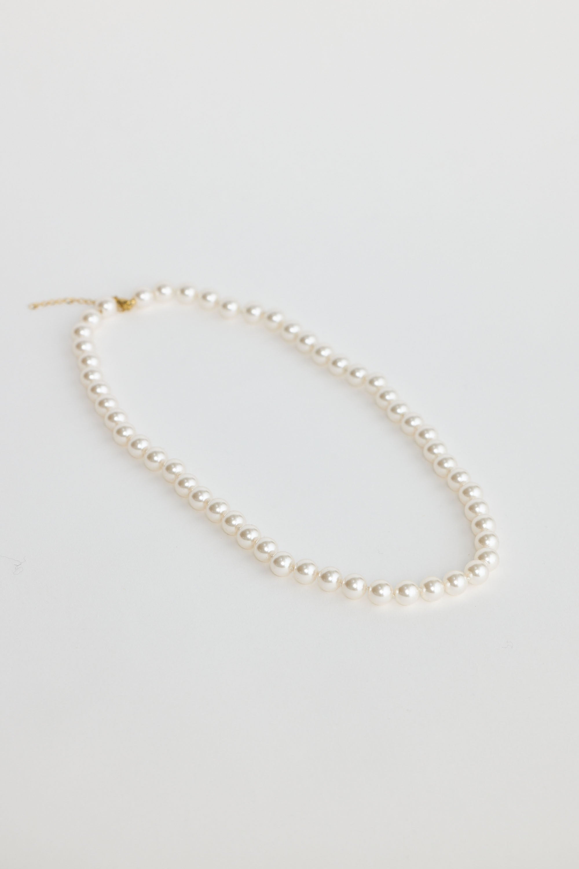 Pearl necklace on a light gray background