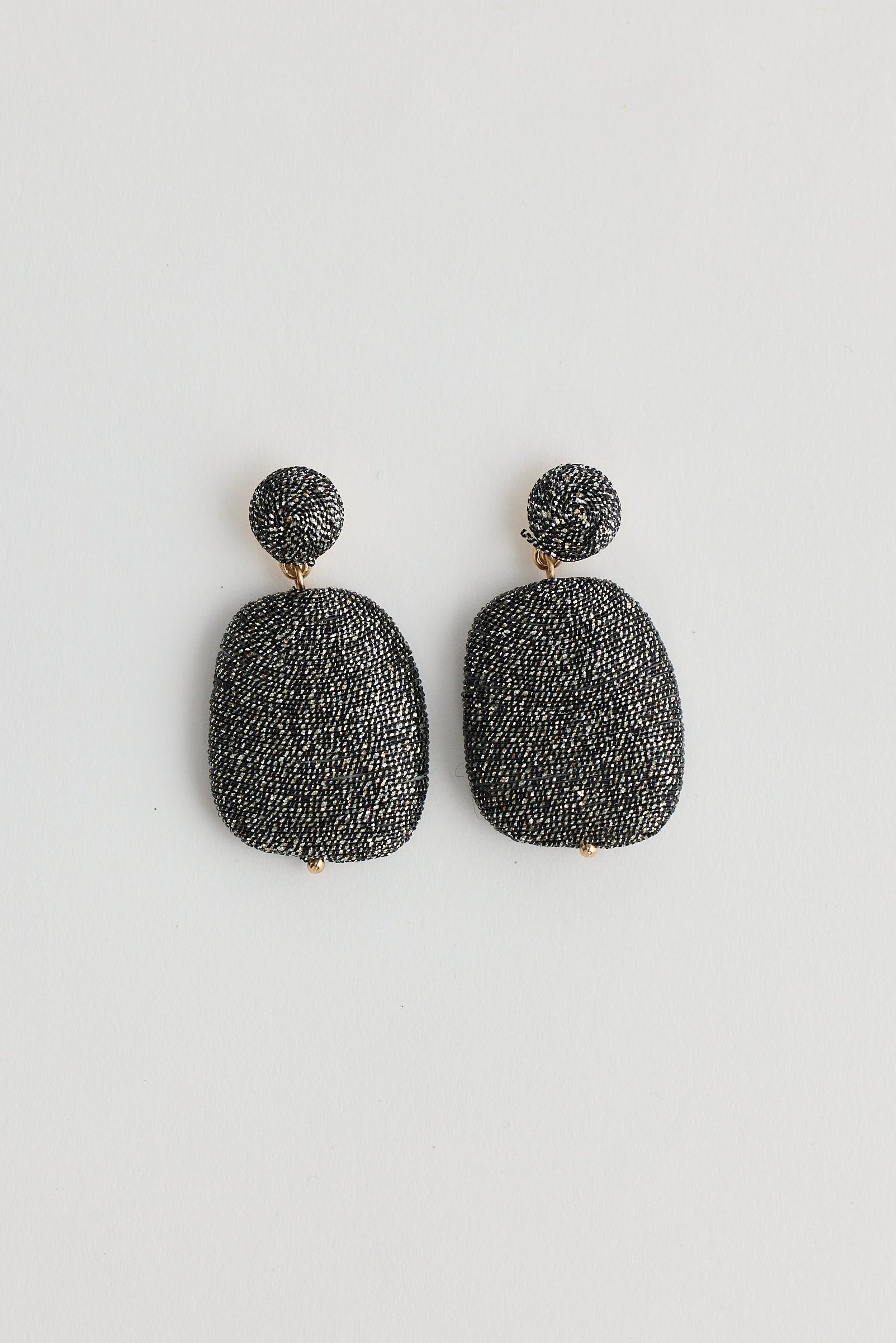 Pair of black textured earrings on a white background