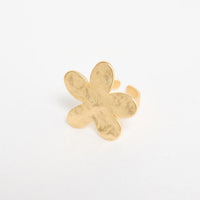 Gold-tone adjustable ring with a large daisy flower top featuring textured petals and a crystal centre, shown at an angle on a white background