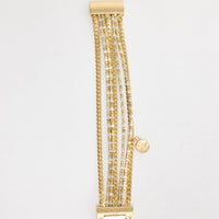 Gold-tone stretch bracelet made of alternating square and rectangular hammered metal panels, shown flat on a white background