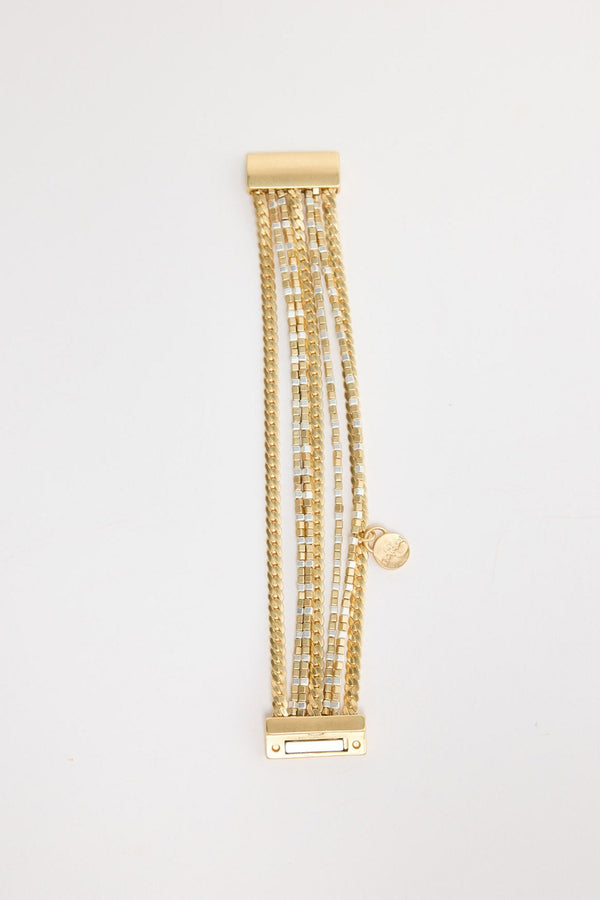 Gold-tone stretch bracelet made of alternating square and rectangular hammered metal panels, shown flat on a white background