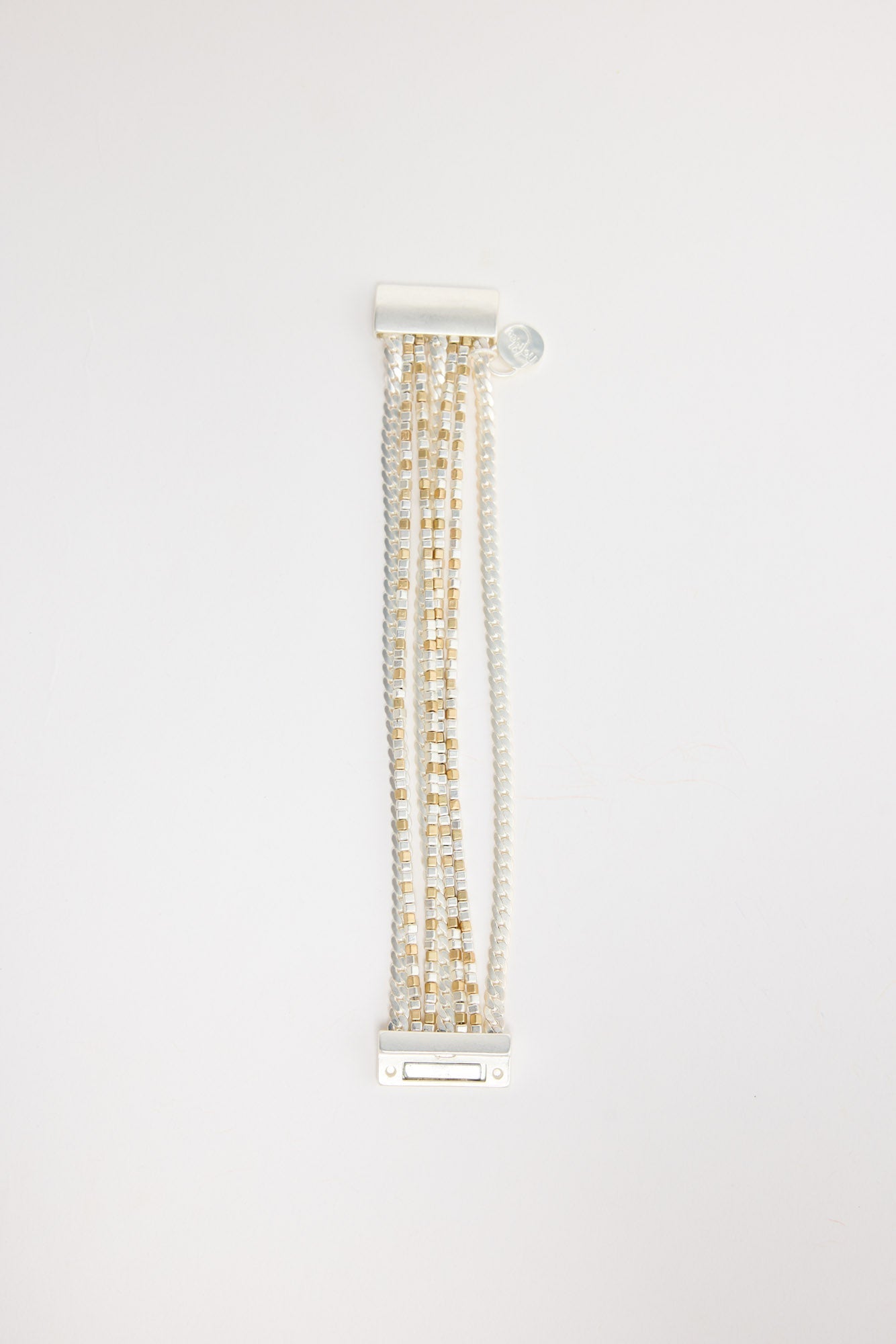 Anderson Bracelet in silver – flat lay showing multiple silver-tone chain strands with gold and silver cube beads and a bar-style clasp