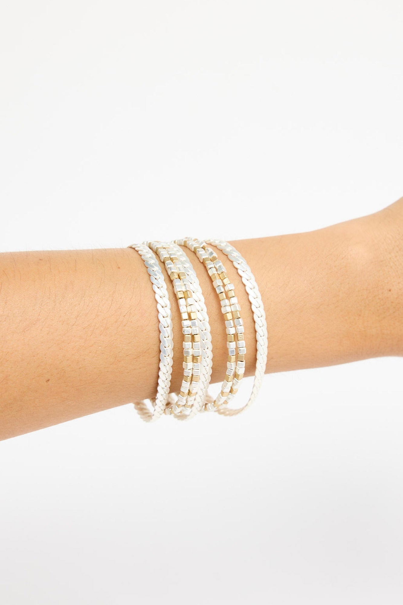 Anderson Bracelet in silver worn stacked on the wrist, showing the layered chain and cube bead detail