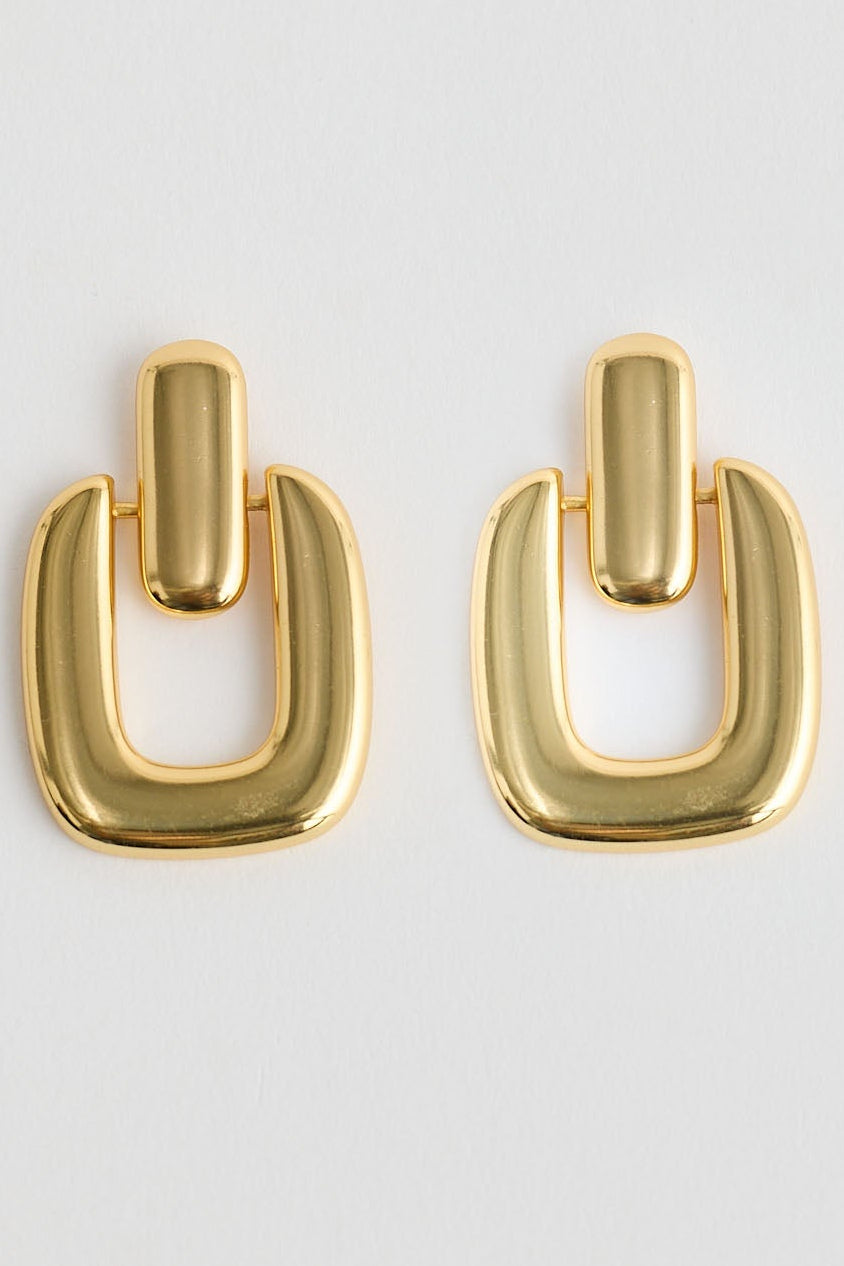 Gold hoop earrings on a light gray background