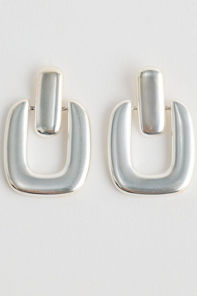 Pair of silver hoop earrings on a light gray background