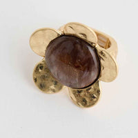 Gold ring with a brown gemstone on a white background