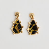 Pair of earrings with black and gold design on a white background