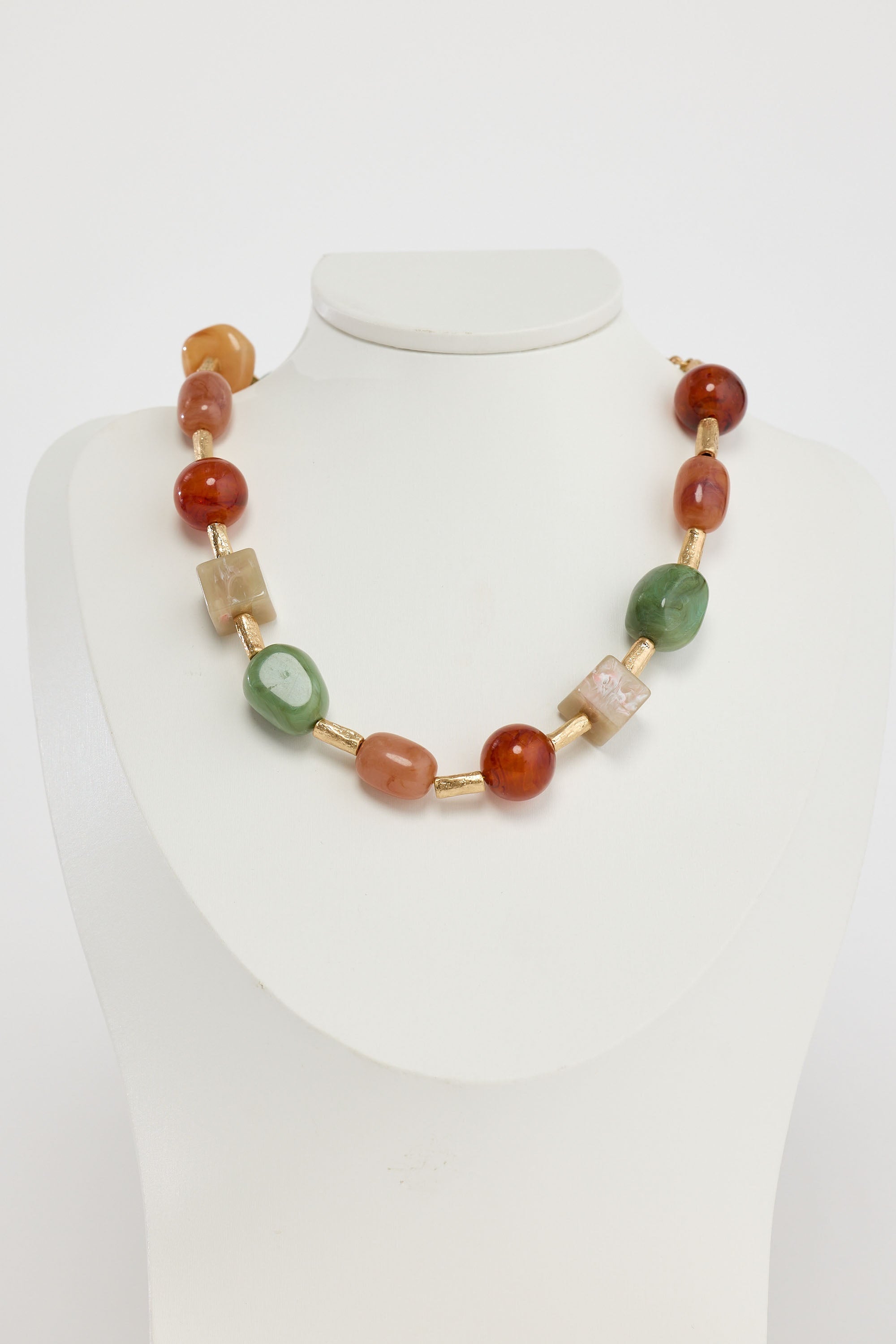 Necklace with multicolored beads on a mannequin against a white background