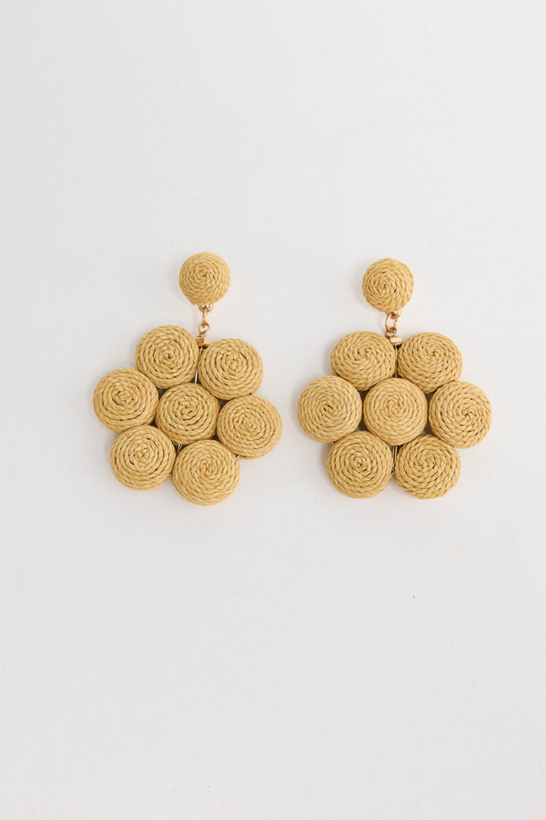 Pair of large statement drop earrings made of seven coiled natural raffia rosettes arranged in a flower shape, with a matching round raffia stud, laid flat on a white background