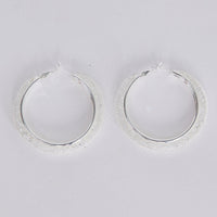 Graceful Earrings in silver with soft textured finish, front view.