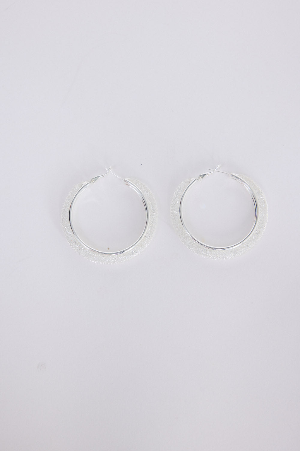 Model wearing Graceful Earrings in silver with soft textured finish, side profile view.