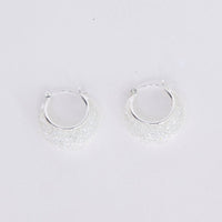 Small hoop earrings on a light gray background