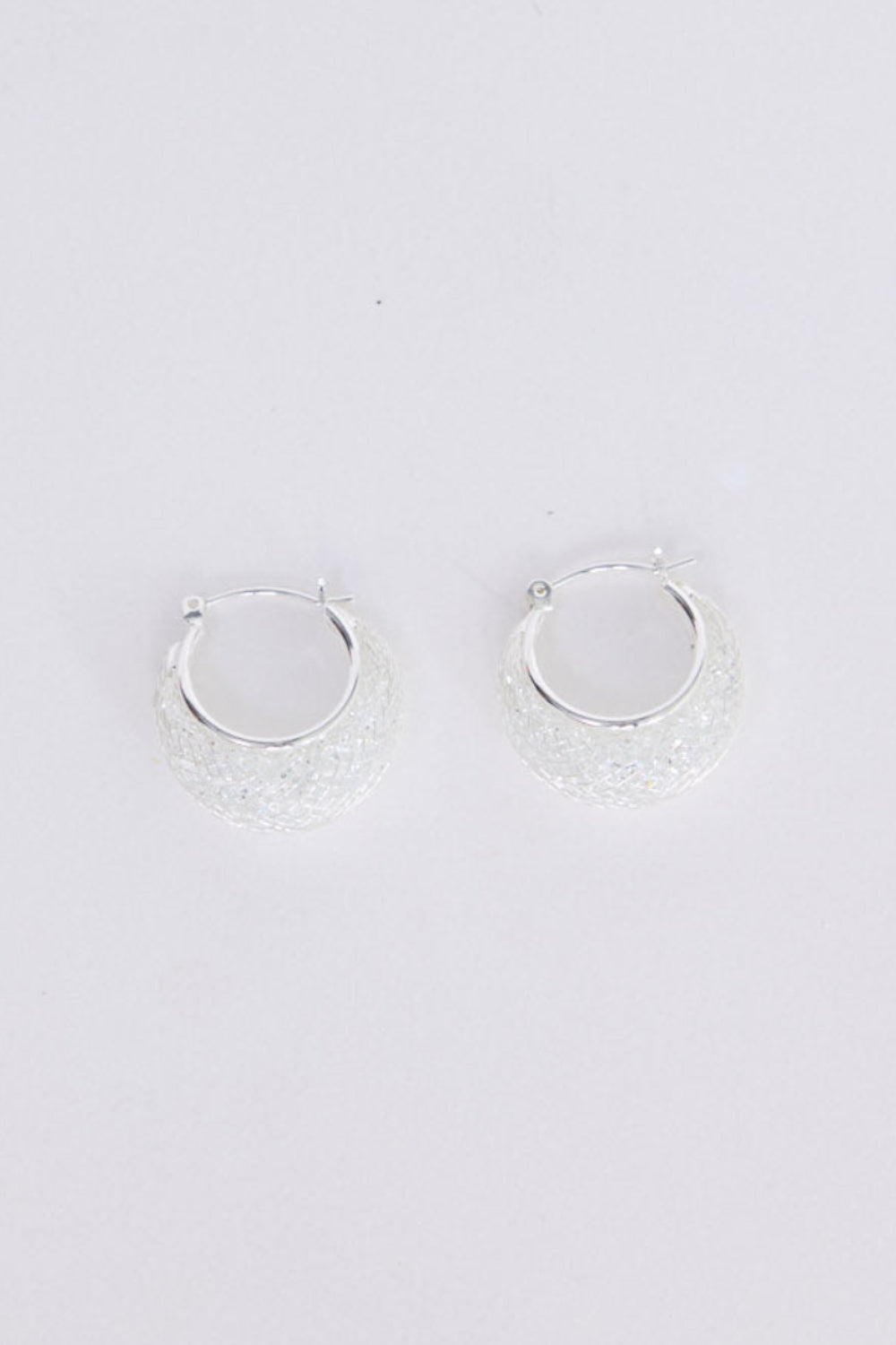 Small hoop earrings on a light gray background
