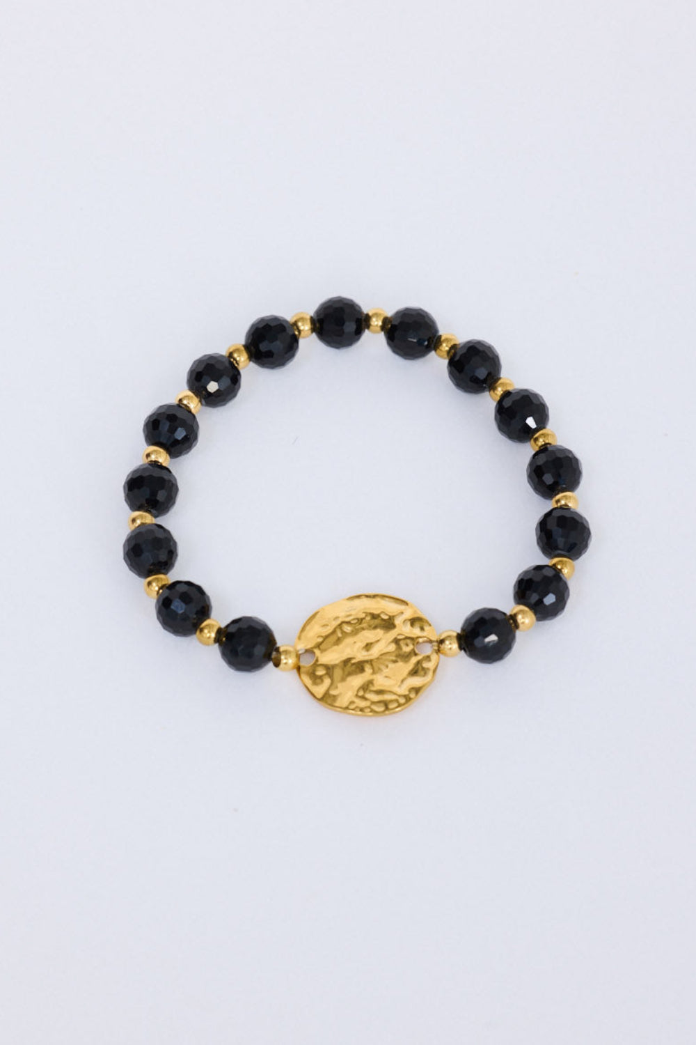 Taylor Bracelet in black with statement gold charm detail, front view.