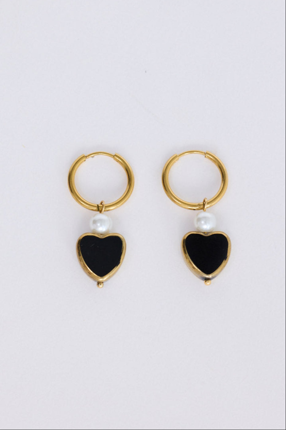 Mimi Earrings in black with bold heart charm detail, angled view.