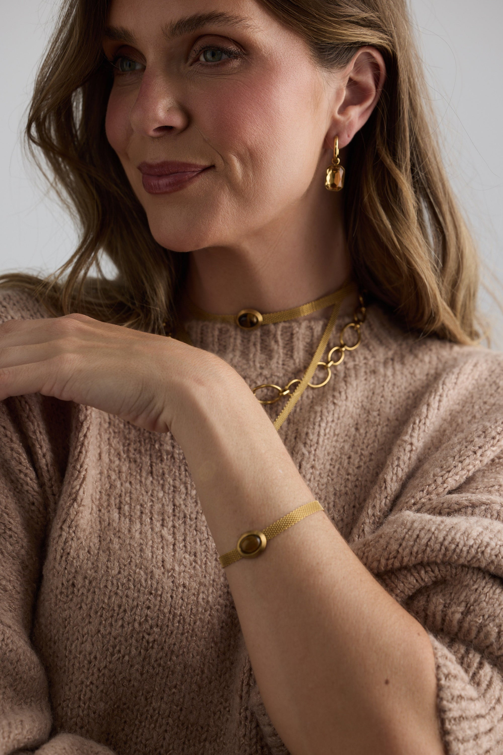 Model wearing Dorris Bracelet in amber with a central oval stone detail, on-wrist detail view.
