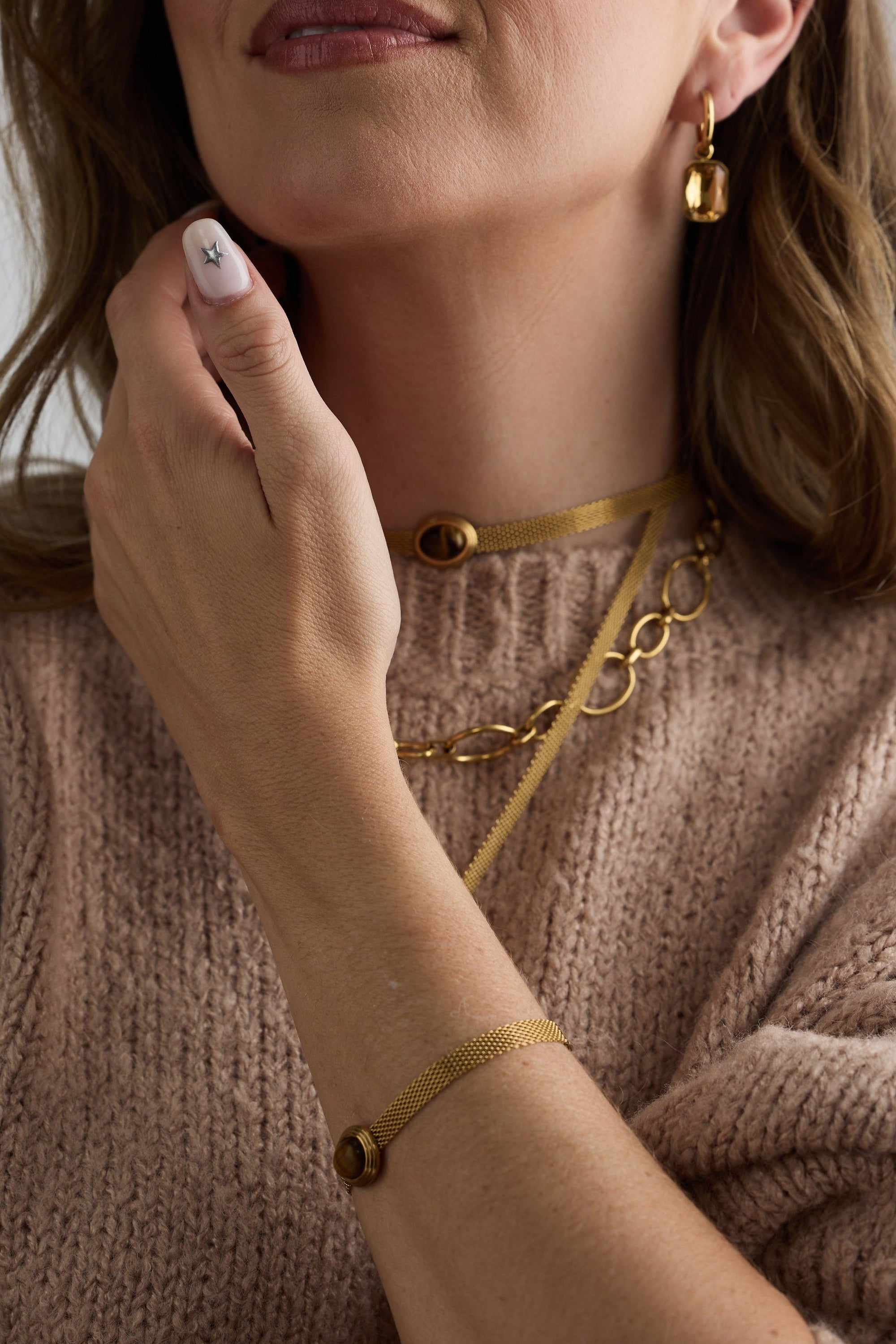 Model wearing Dorris Bracelet in amber with a central oval stone detail, on-wrist view.