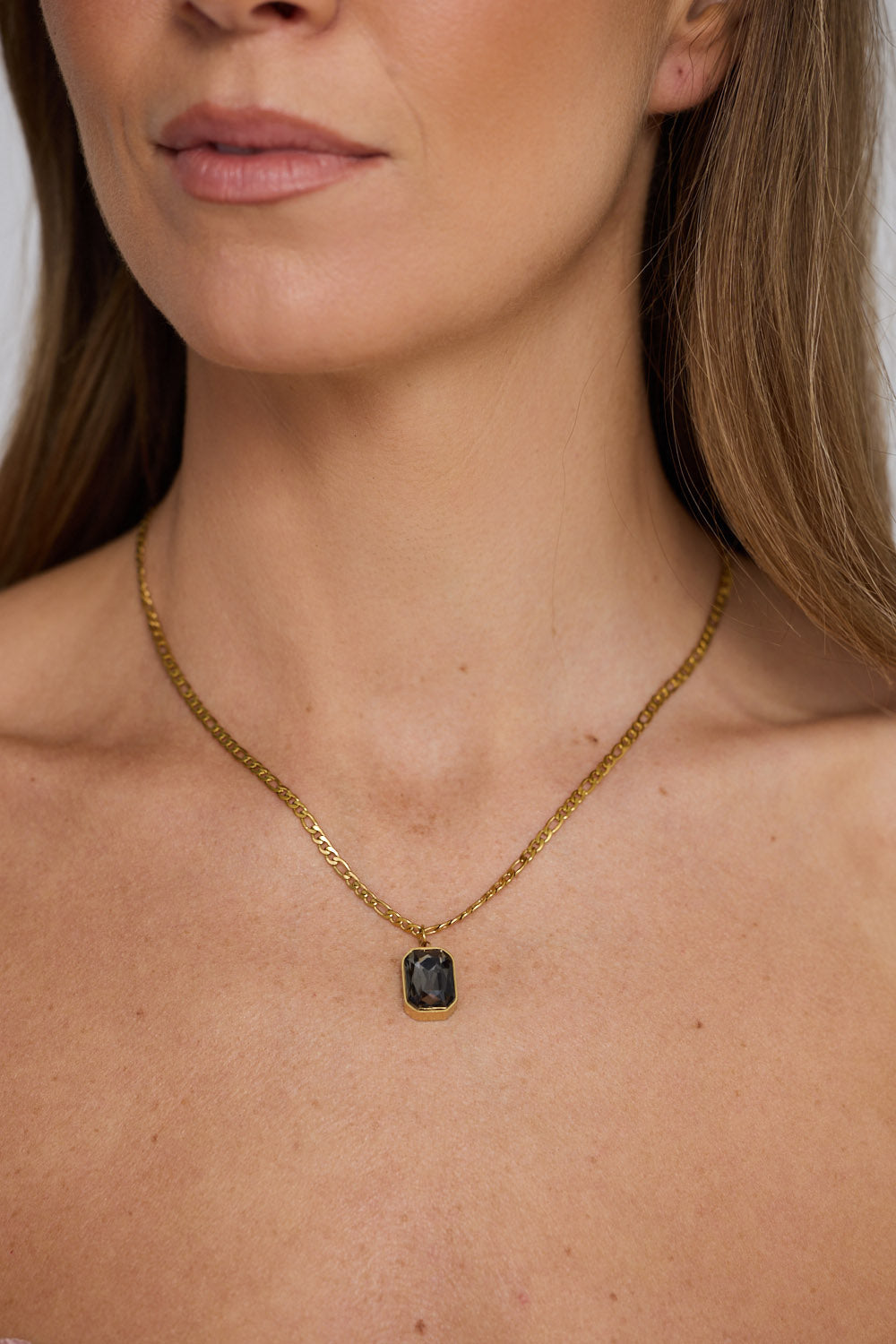 Bovina Necklace in smoke with a faceted rectangular pendant, neckline styled view.