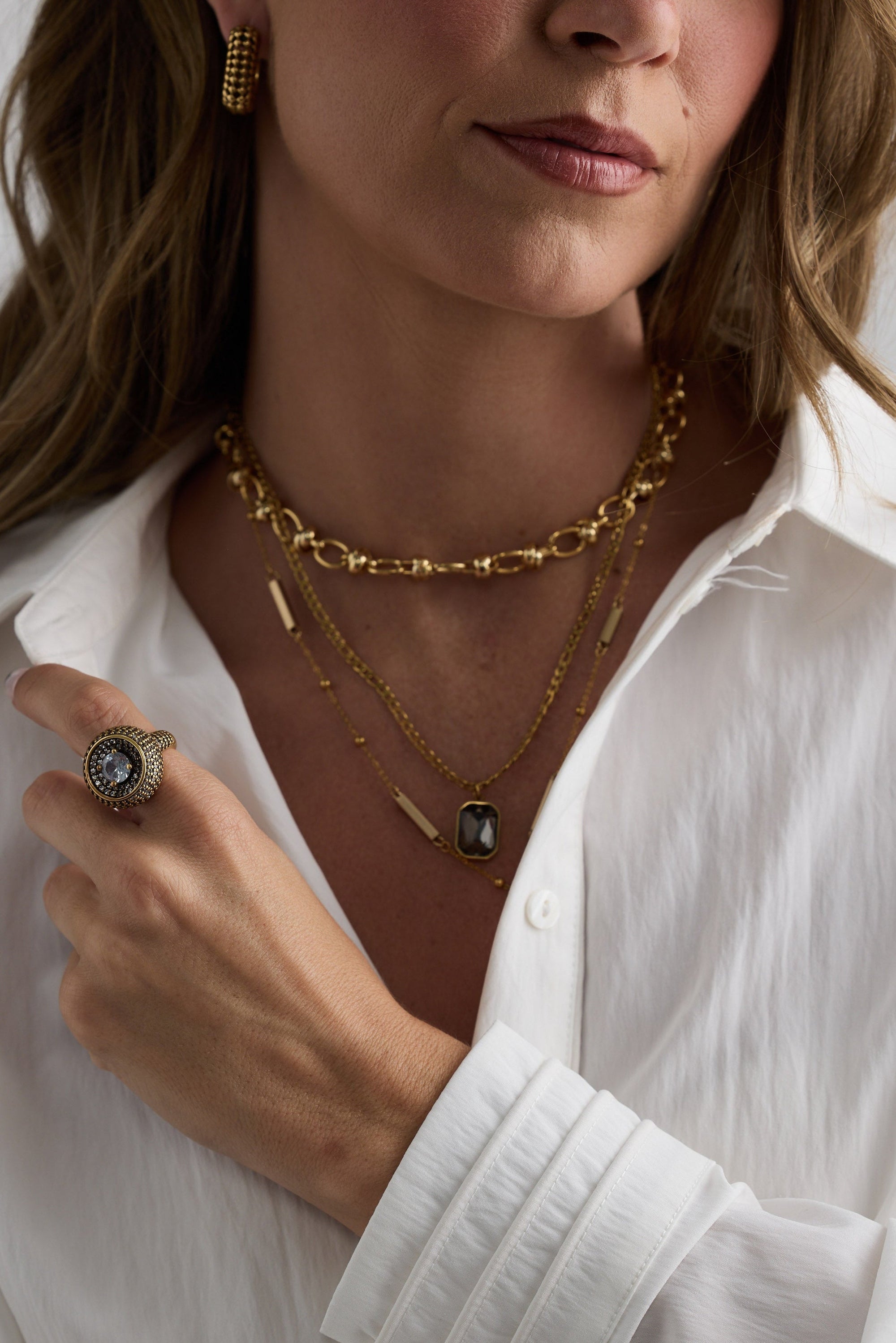 Model wearing Bovina Necklace in smoke with a faceted rectangular pendant, layered styling view.