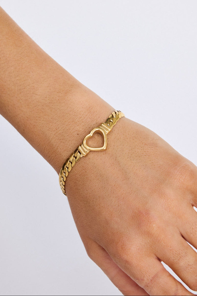 Model wearing Hearts Bracelet in gold with delicate heart link detailing, on-wrist view.