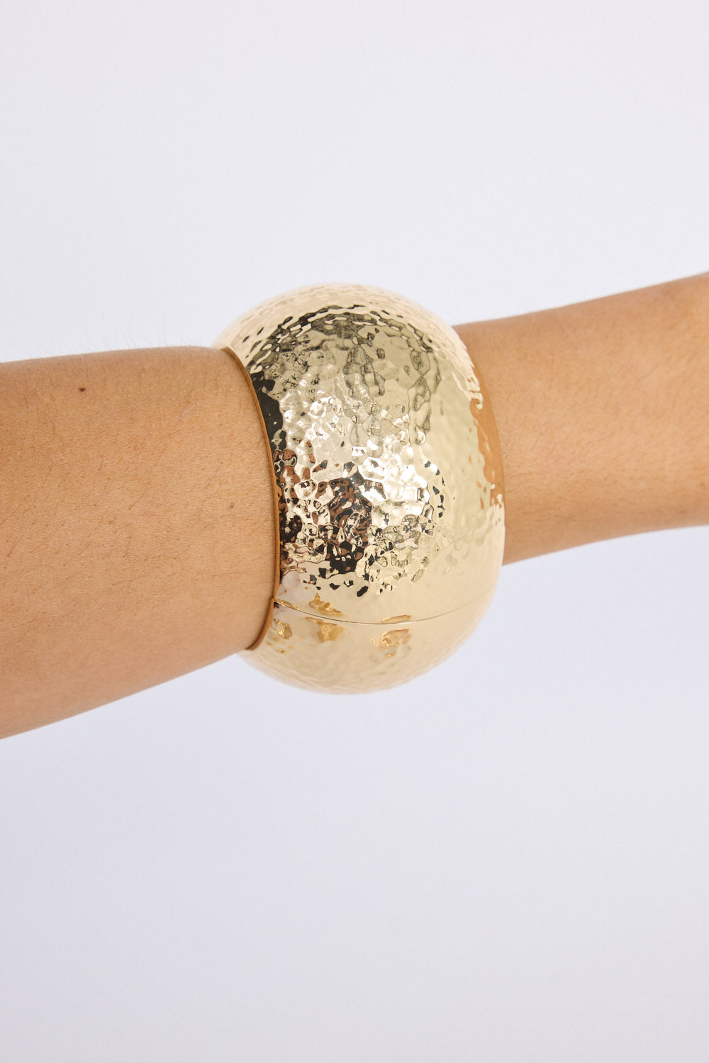 Model wearing Maura Bangle in gold with snap lock closure and hinge for easy wear, stacked view.