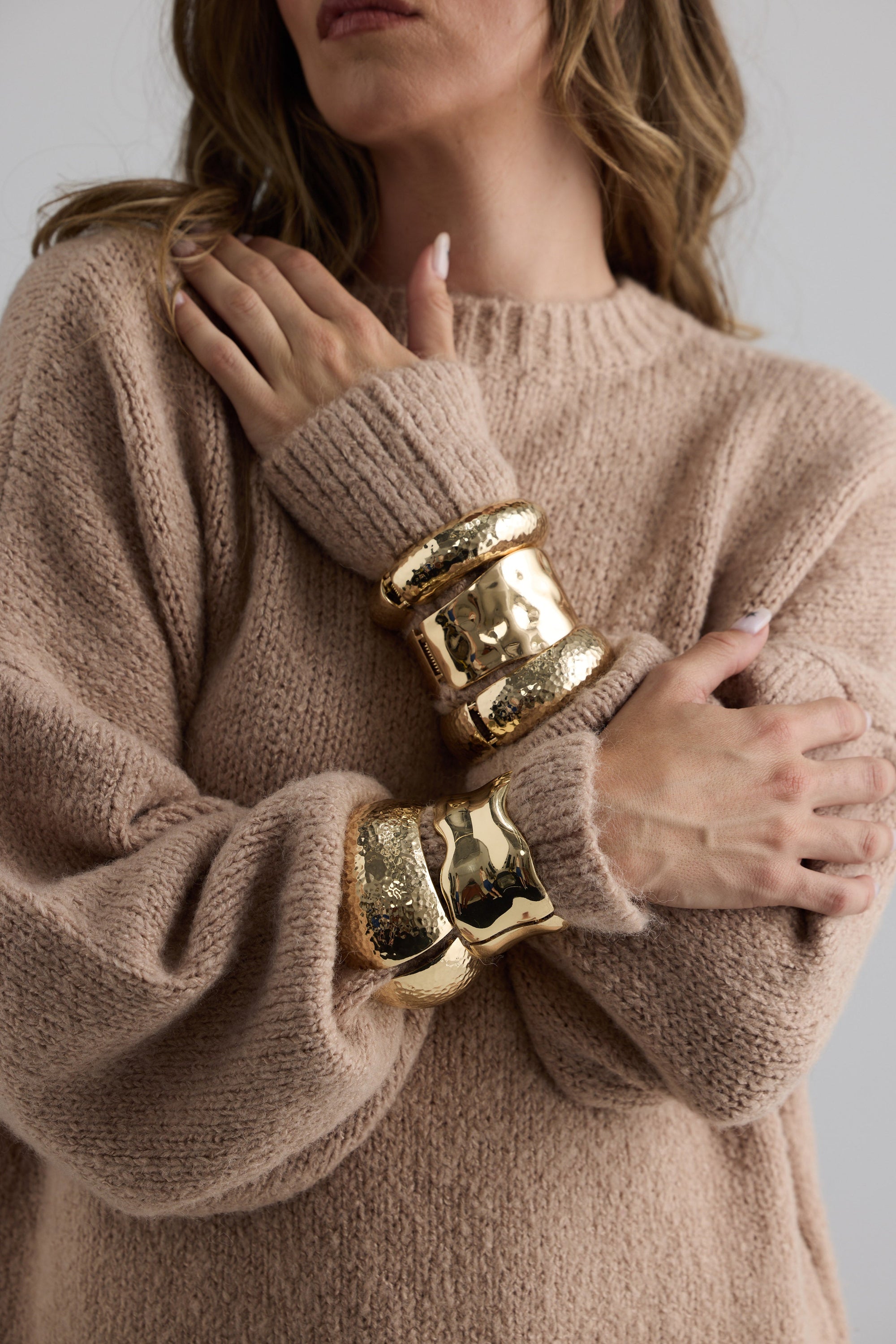 Model wearing Maura Bangle in gold with snap lock closure and hinge for easy wear, bracelet detail view.