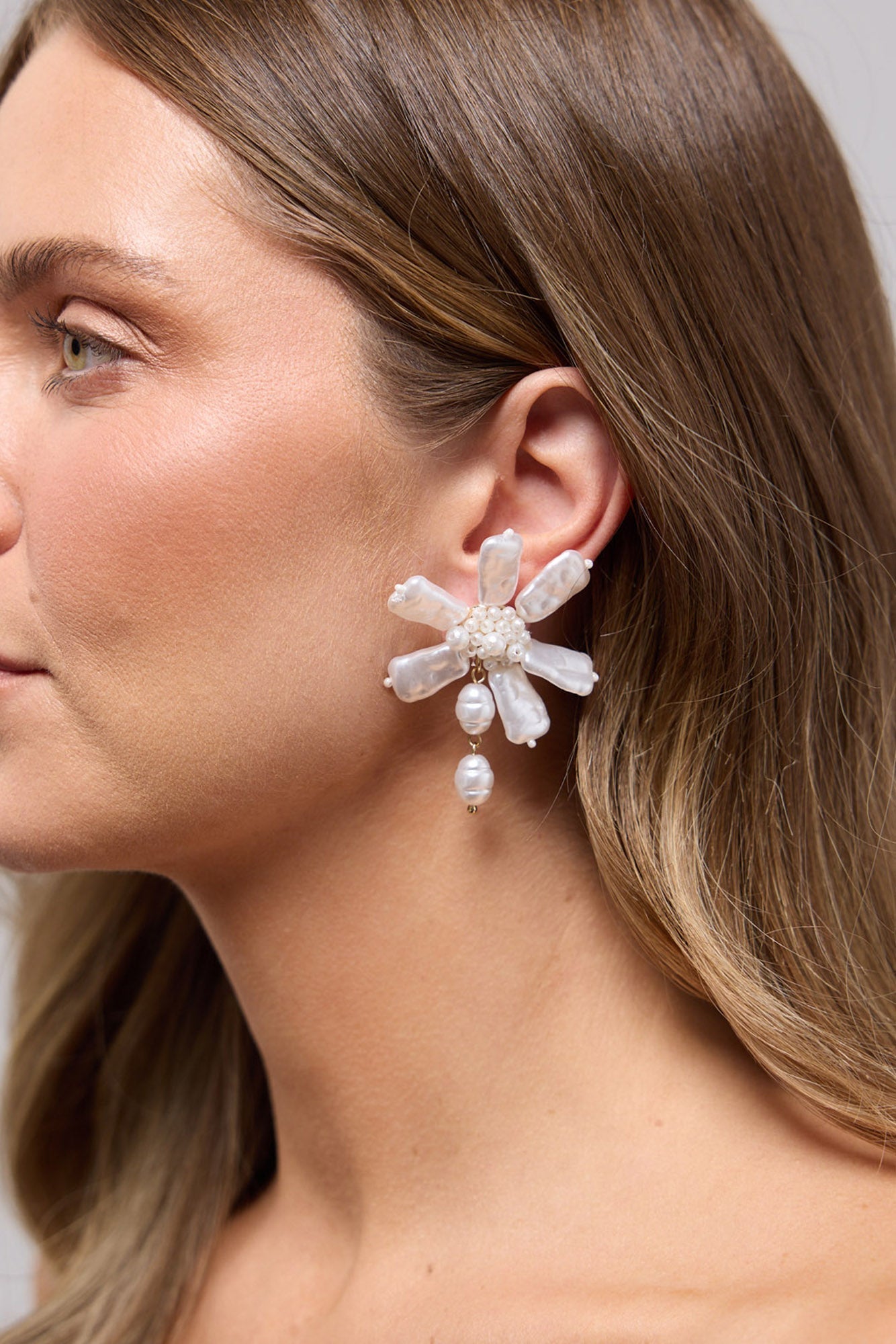 Zara floral earring in Pearl worn on the ear, showing the freshwater pearl petals and drop pearl up close