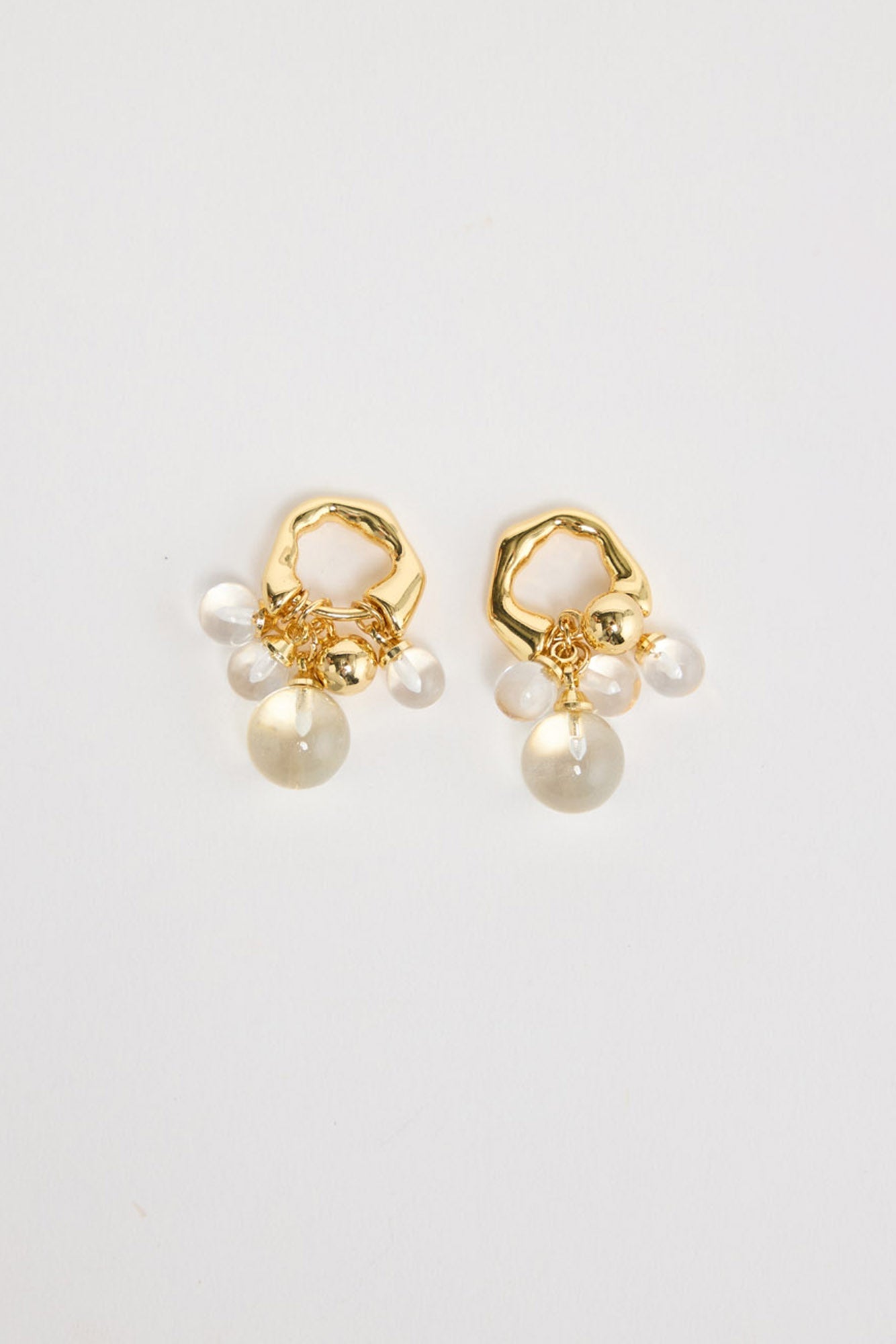 Bubble Earrings in Gold – gold-tone organic hoop earrings with a cluster of clear glass bubble beads, shown flat on a white background.