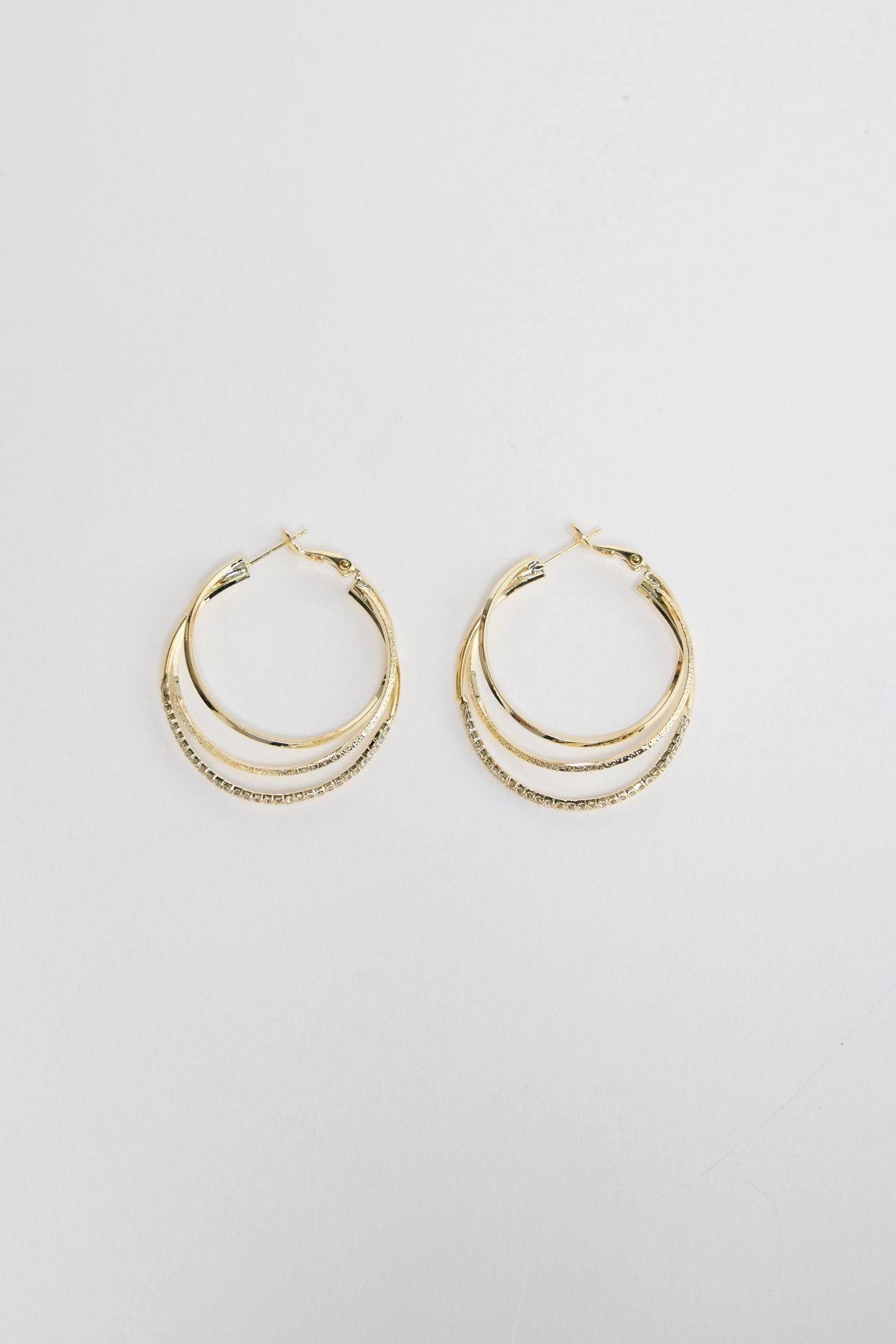Seaspray Earrings in Gold – triple-layer gold-tone hoop earrings with one crystal-set row, shown flat on a white background.