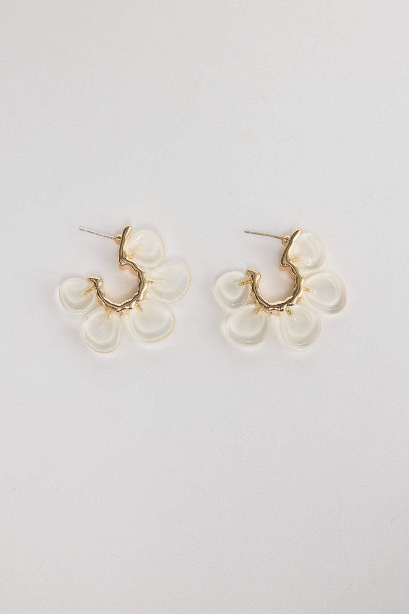 Matilda Earrings in Clear – gold-tone huggie earrings with five frosted clear resin flower petals, shown flat on a white background.