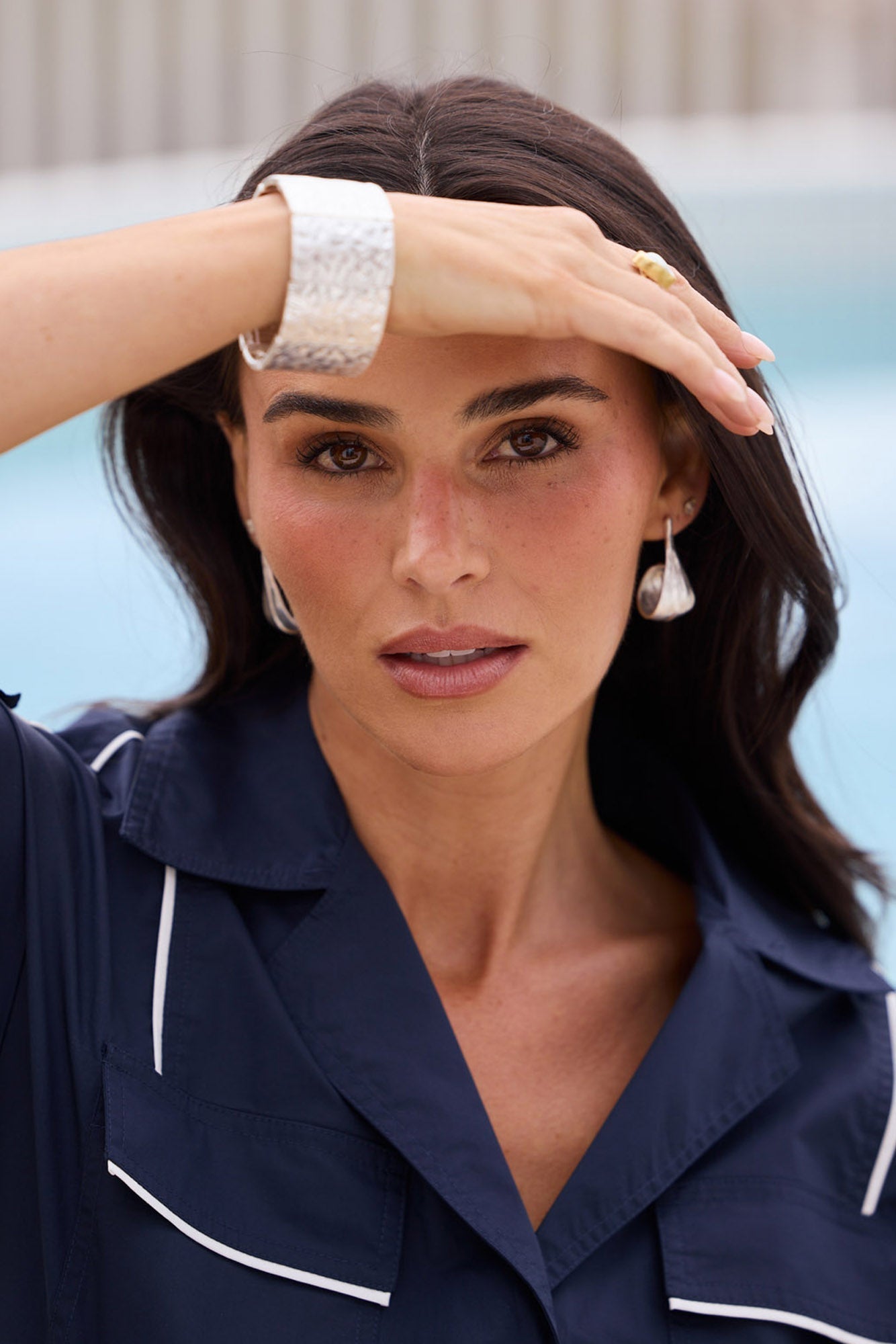 Model wearing both Lagoona Earrings in Silver, teardrop silhouette visible on both ears in a candid campaign shot.