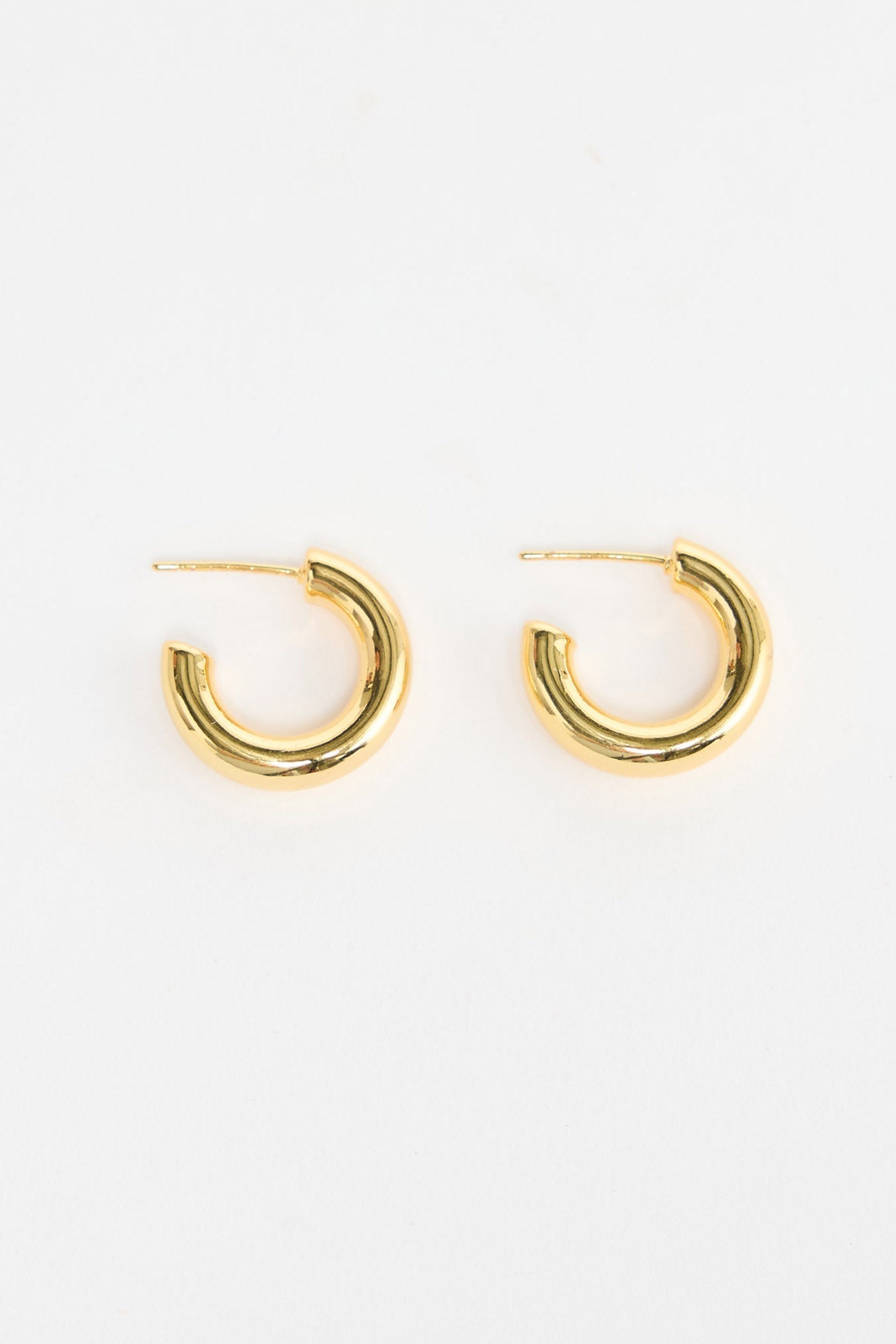 Thick Hoops S in Gold – small polished gold-tone tube hoop earrings shown flat on a white background.