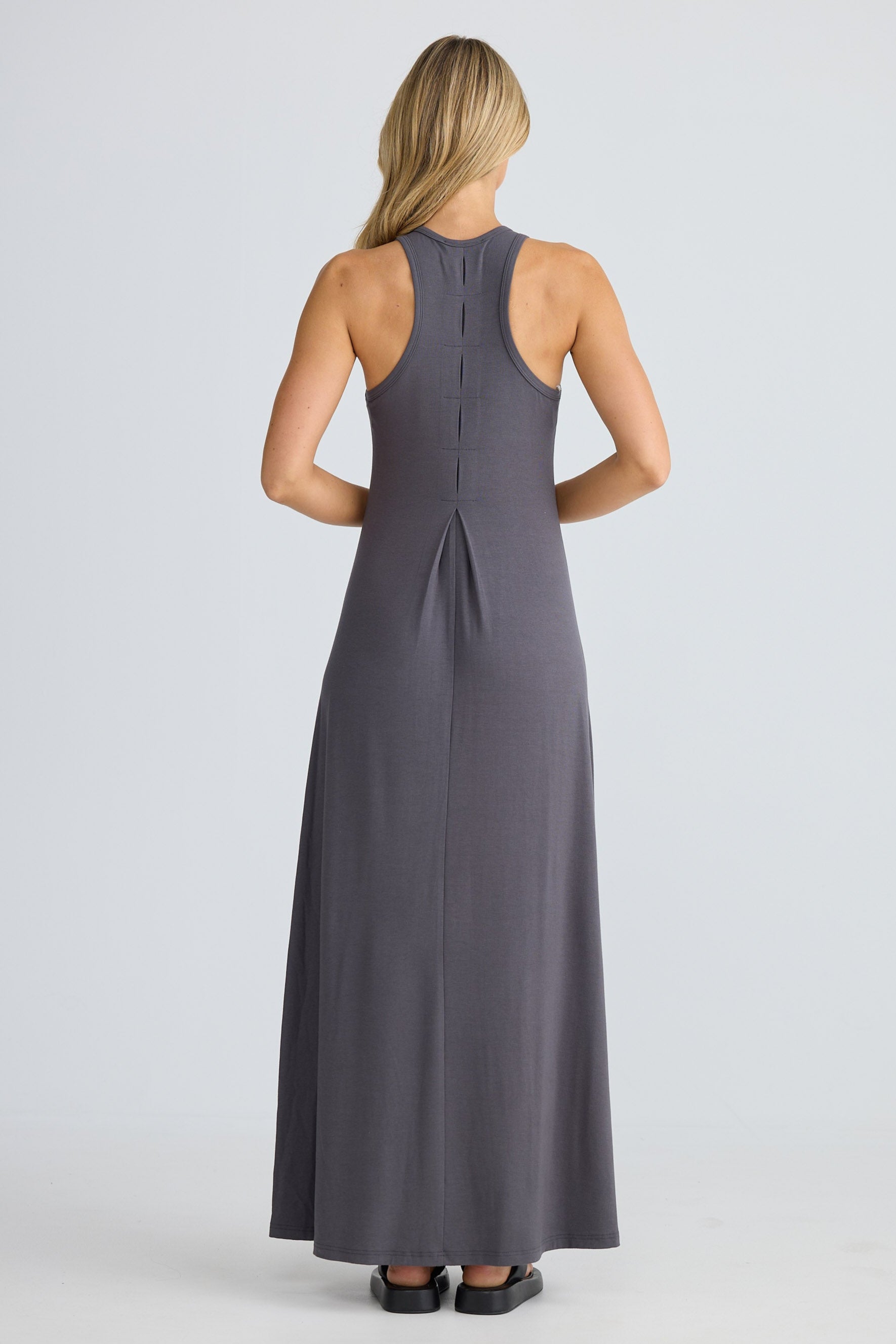 Woman wearing a long gray dress on a white background