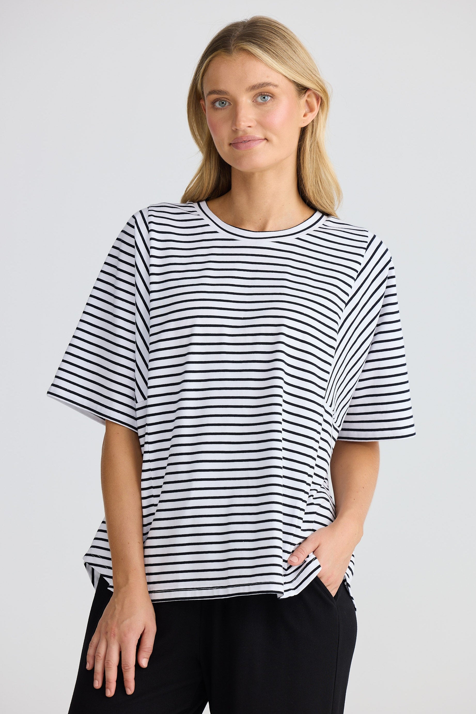 Woman wearing a black and white striped t-shirt against a plain background