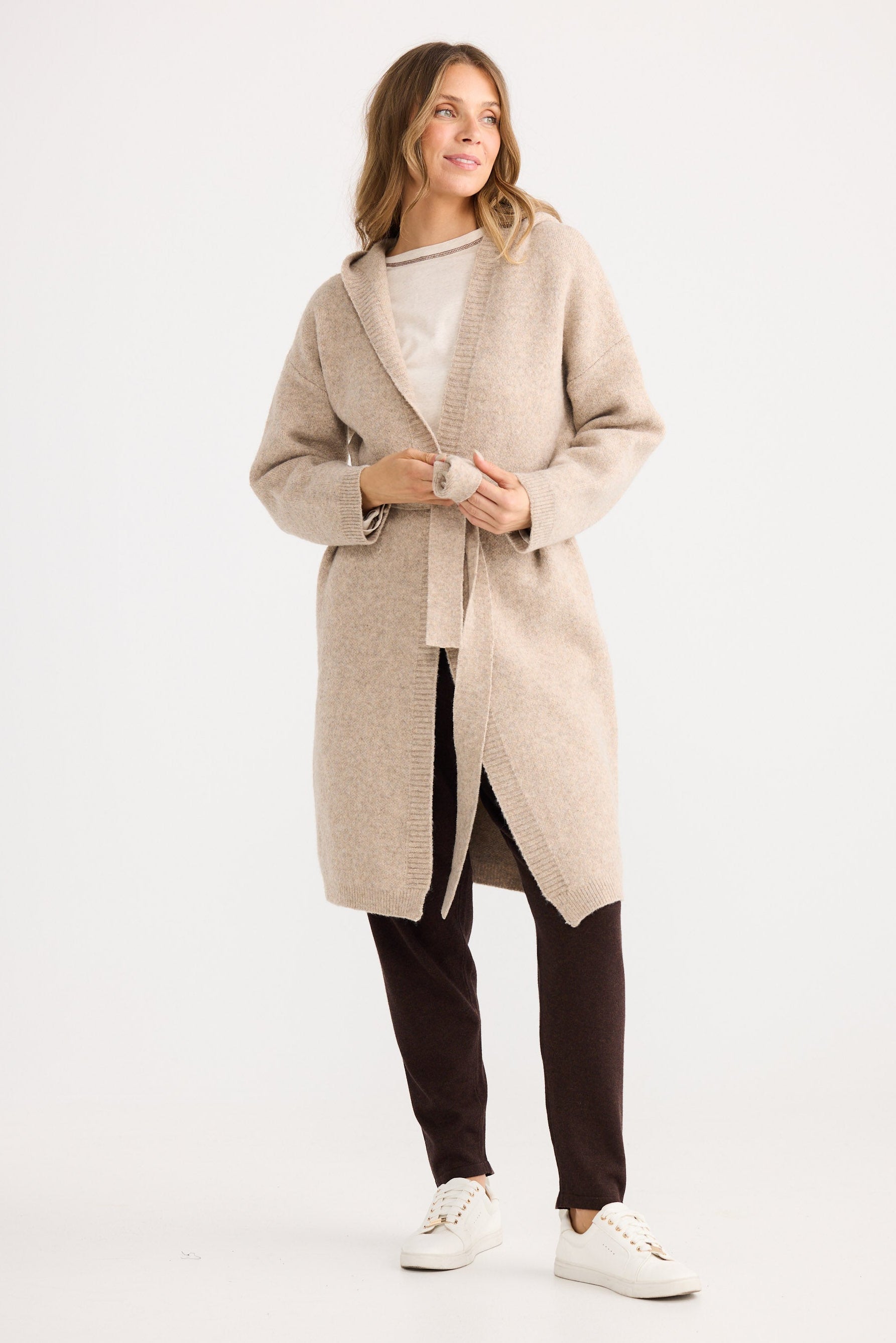 Woman wearing a beige coat on a white background