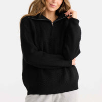 Model wearing Quarter Zip Cable Knit in black.
