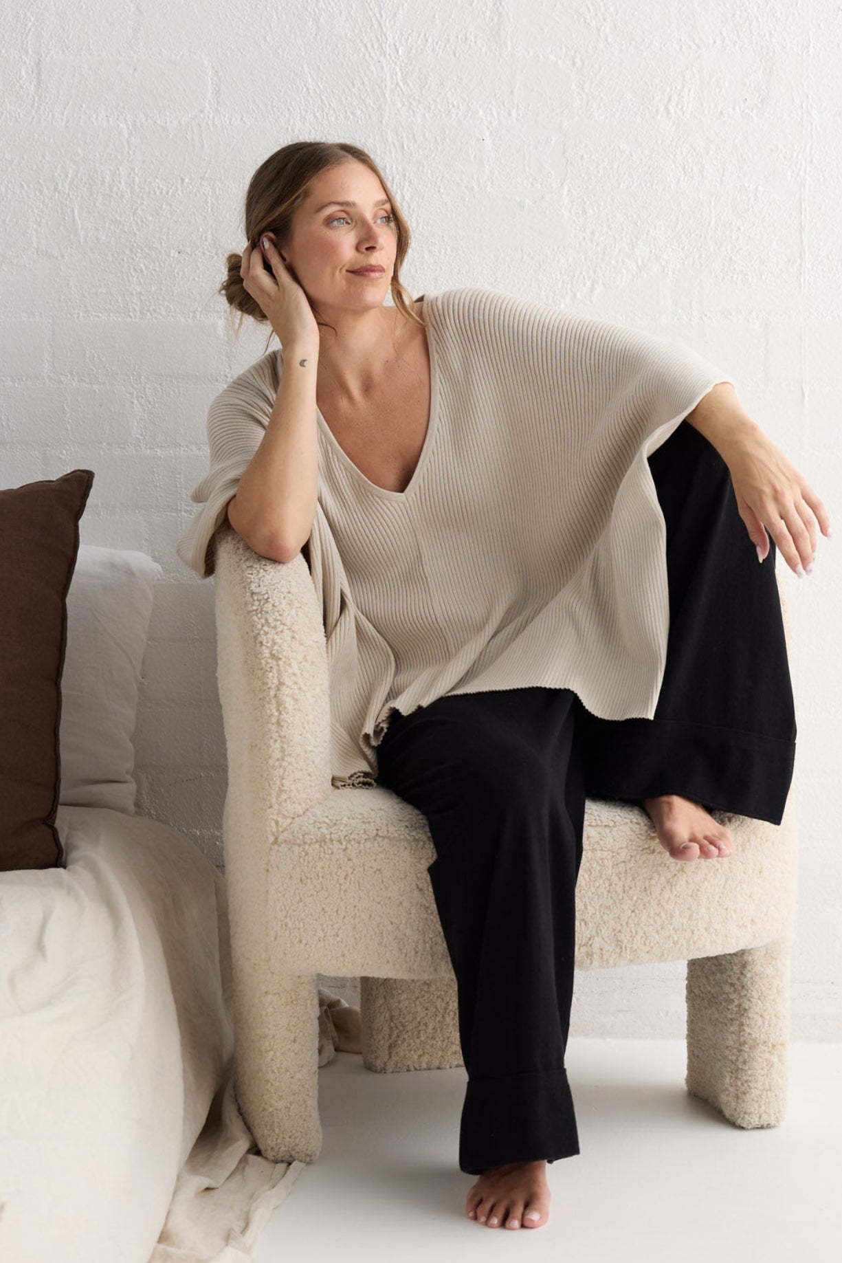 Campaign image of model wearing Affirm Cape in cream.