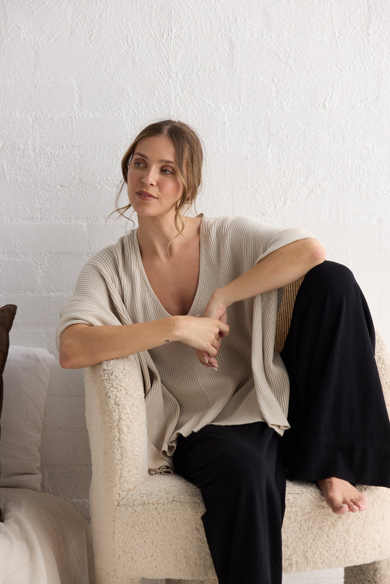 Campaign image of model wearing Affirm Cape in cream.