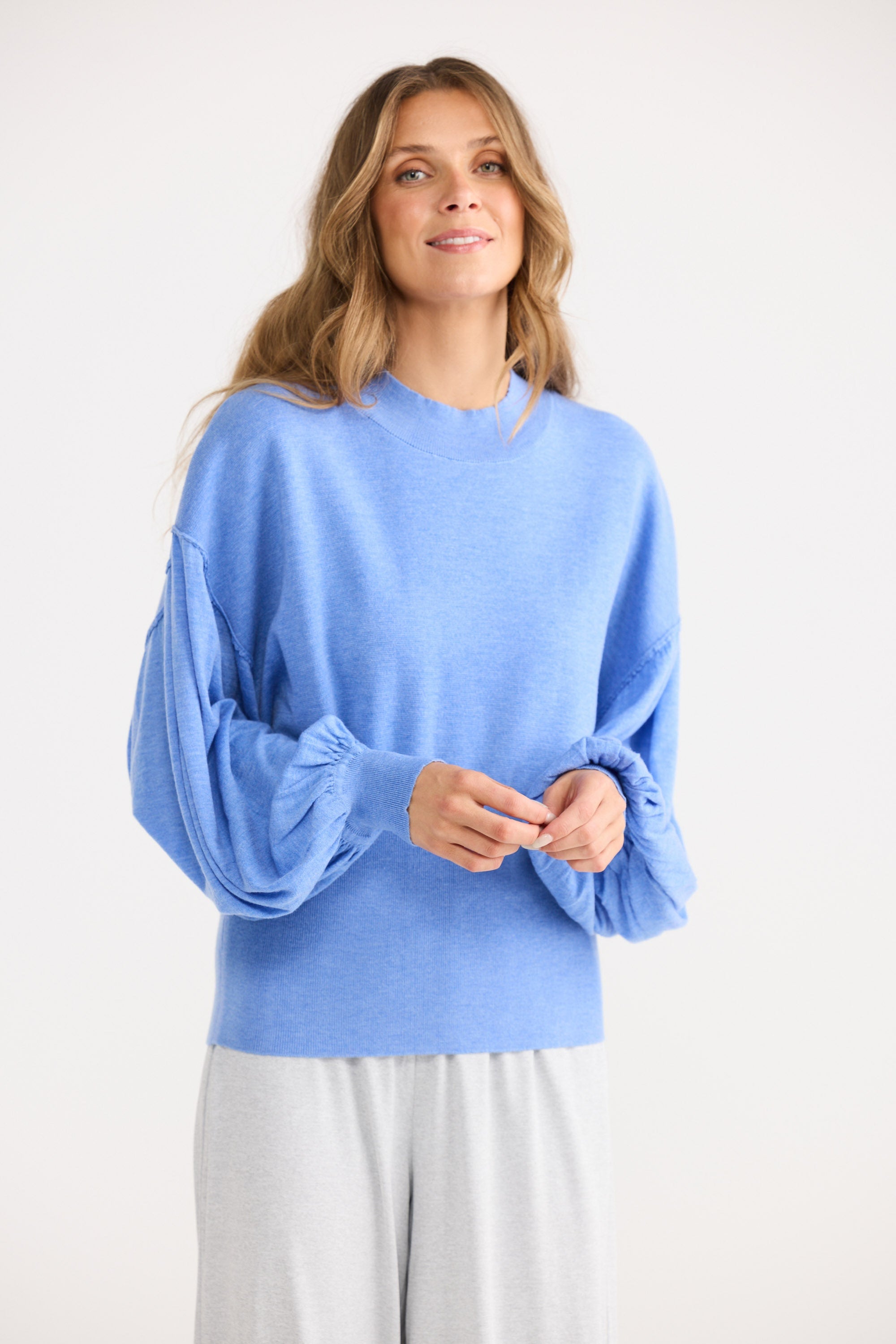 Woman wearing a blue sweater on a white background