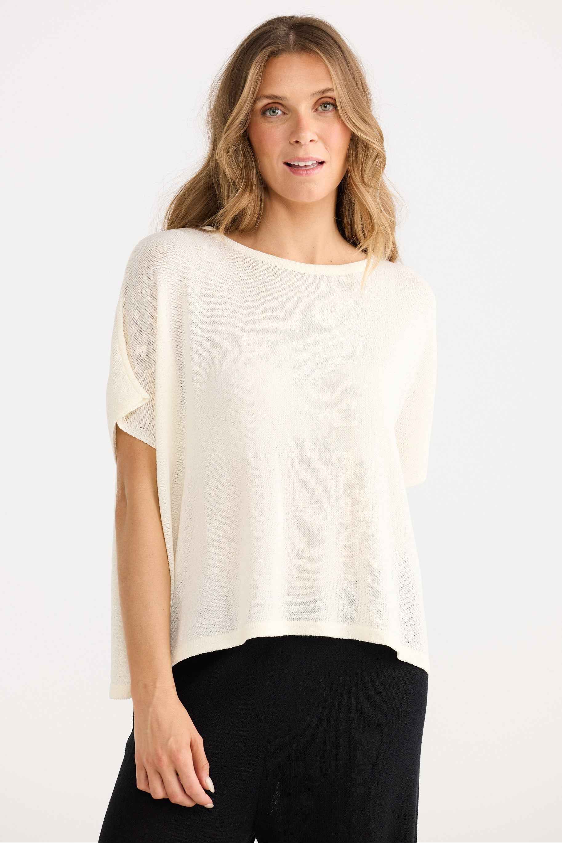 Woman wearing a white blouse and black pants on a white background