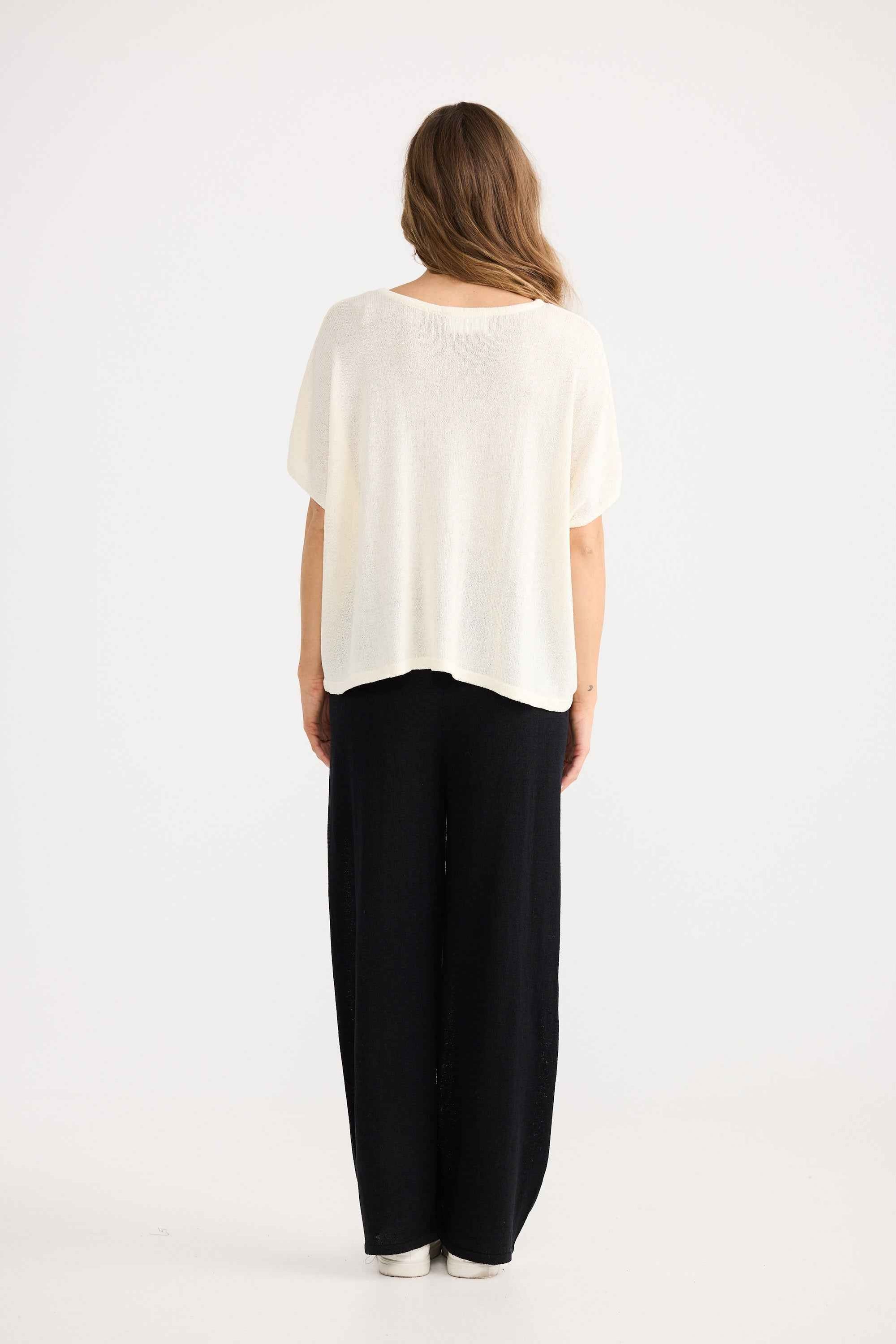 Model wearing Ruthie Knit Top in cream, showing boat neckline.