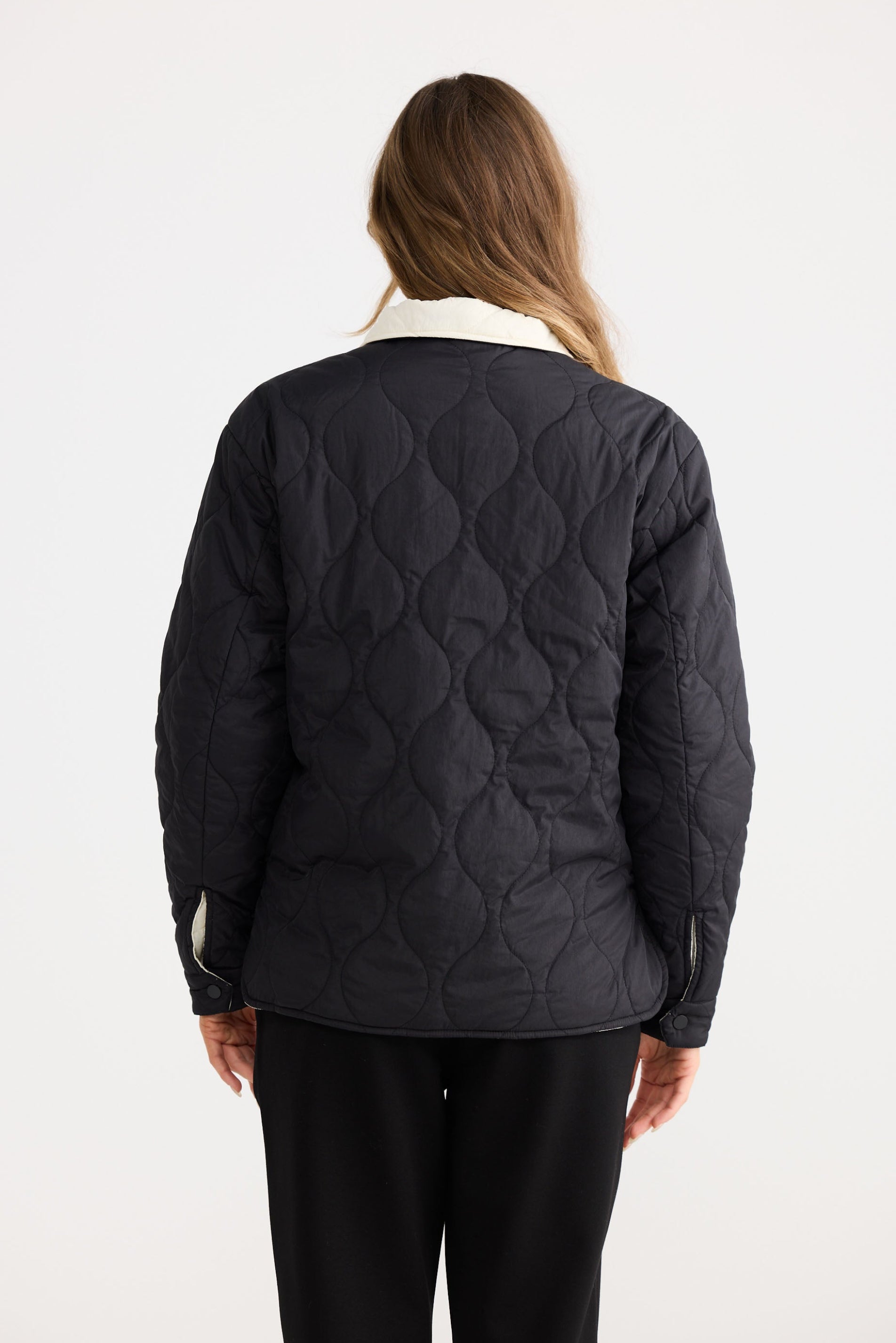 Model wearing Ellis Puffer in black with cream, studio product image.