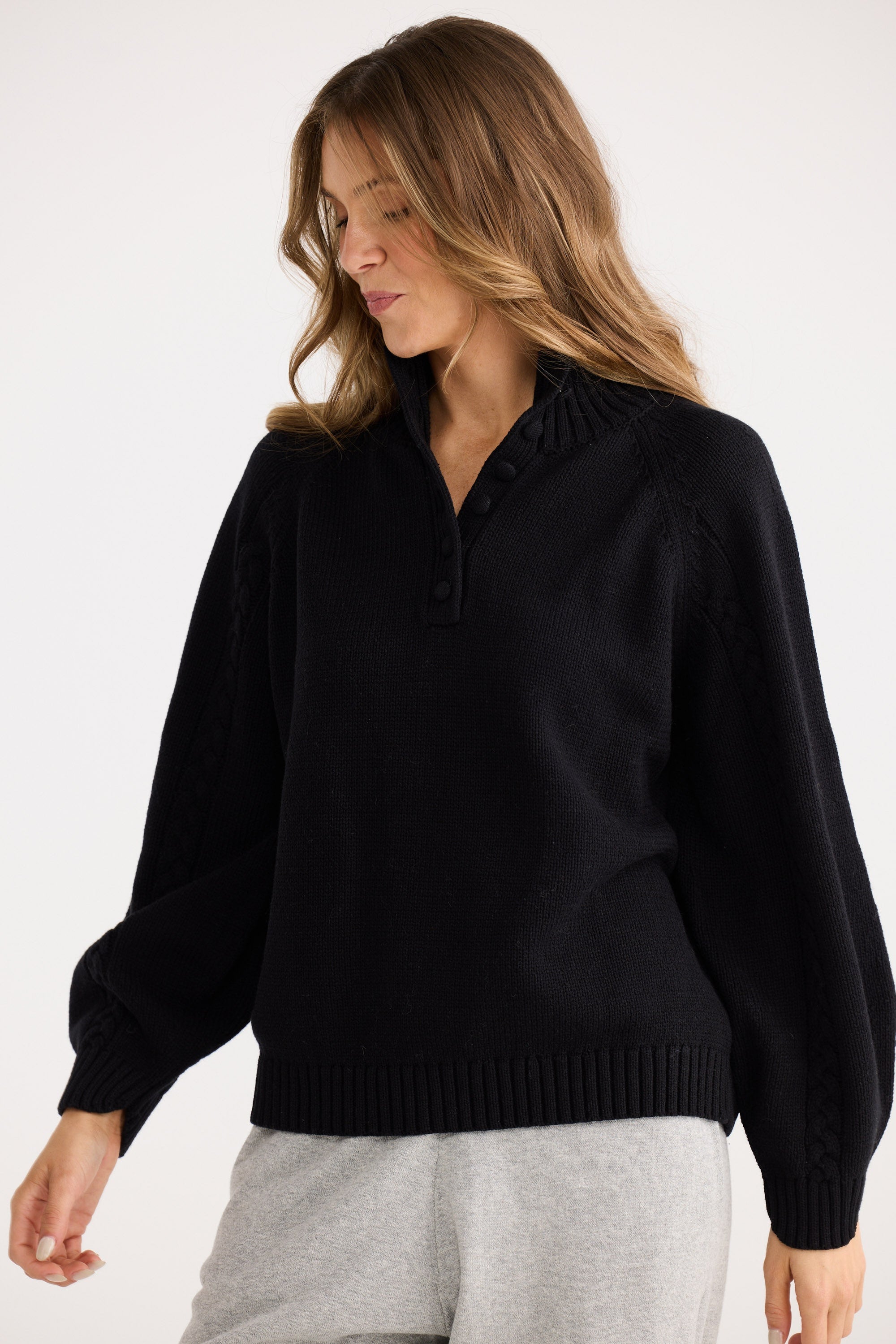 Woman wearing a black sweater against a white background