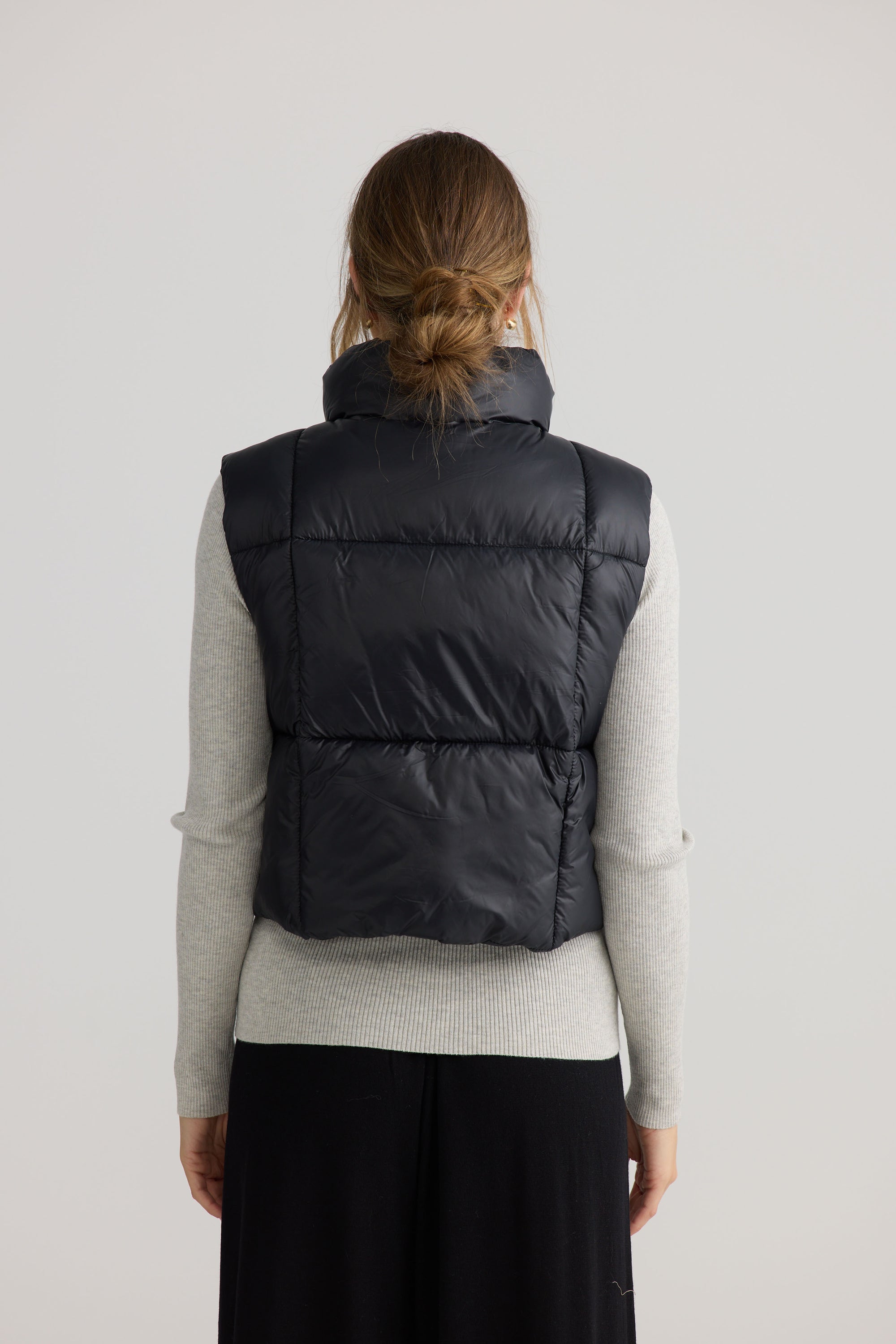 Model wearing Linden Puffer Vest in black.