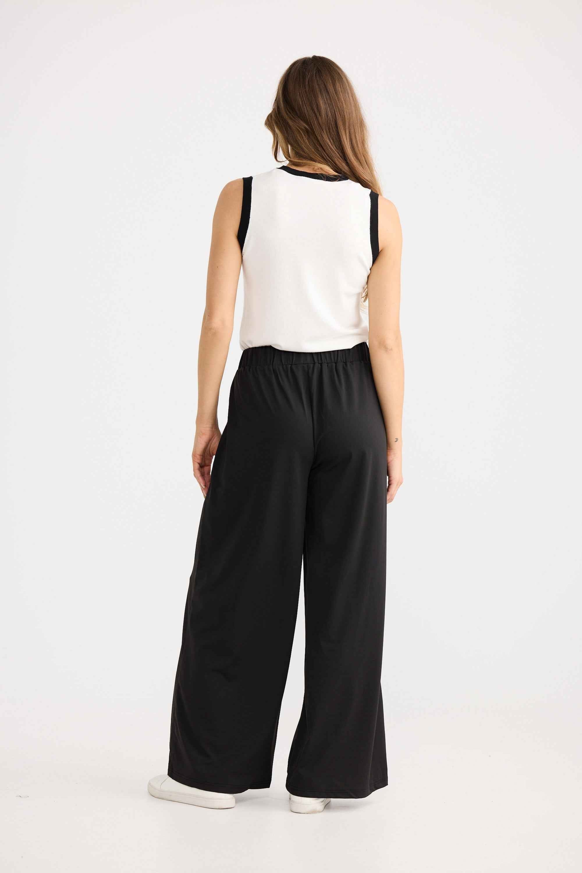 Model wearing Tovi Flare Pant in black, showing elasticated waist.