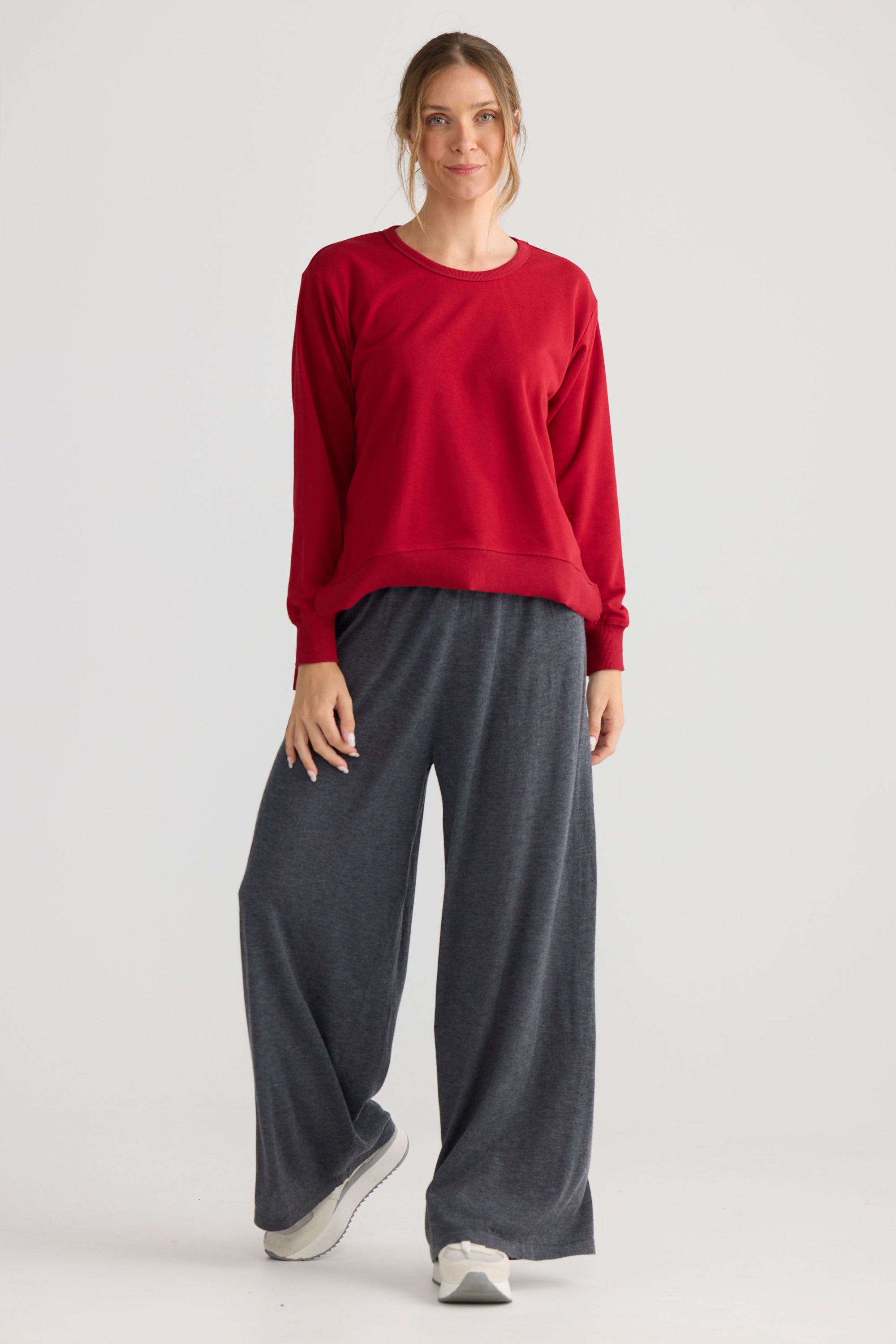 Model wearing Faye Lounge Jumper in scarlet, styled for everyday wear.