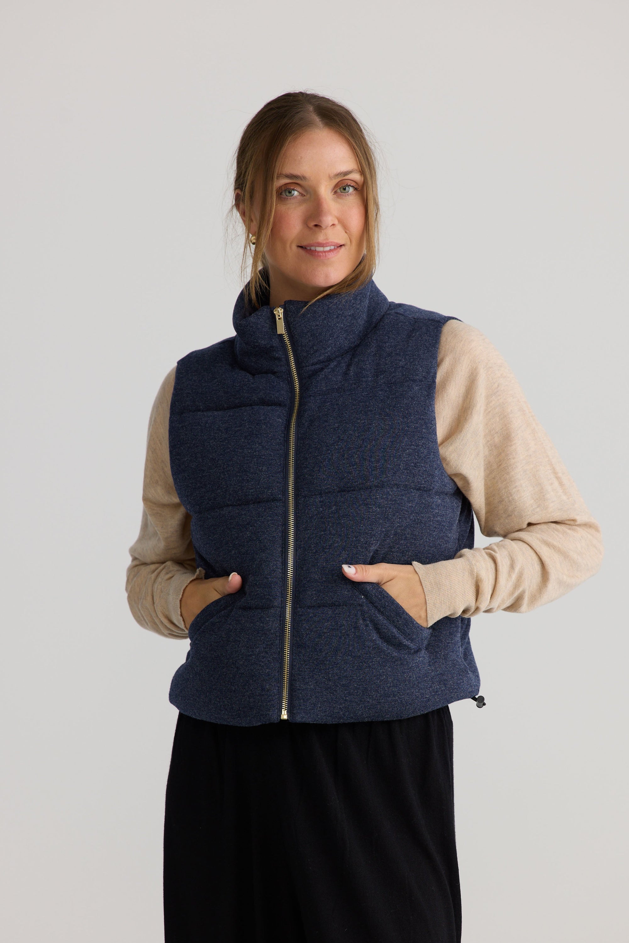 Model wearing Tate Puffer Vest in navy.