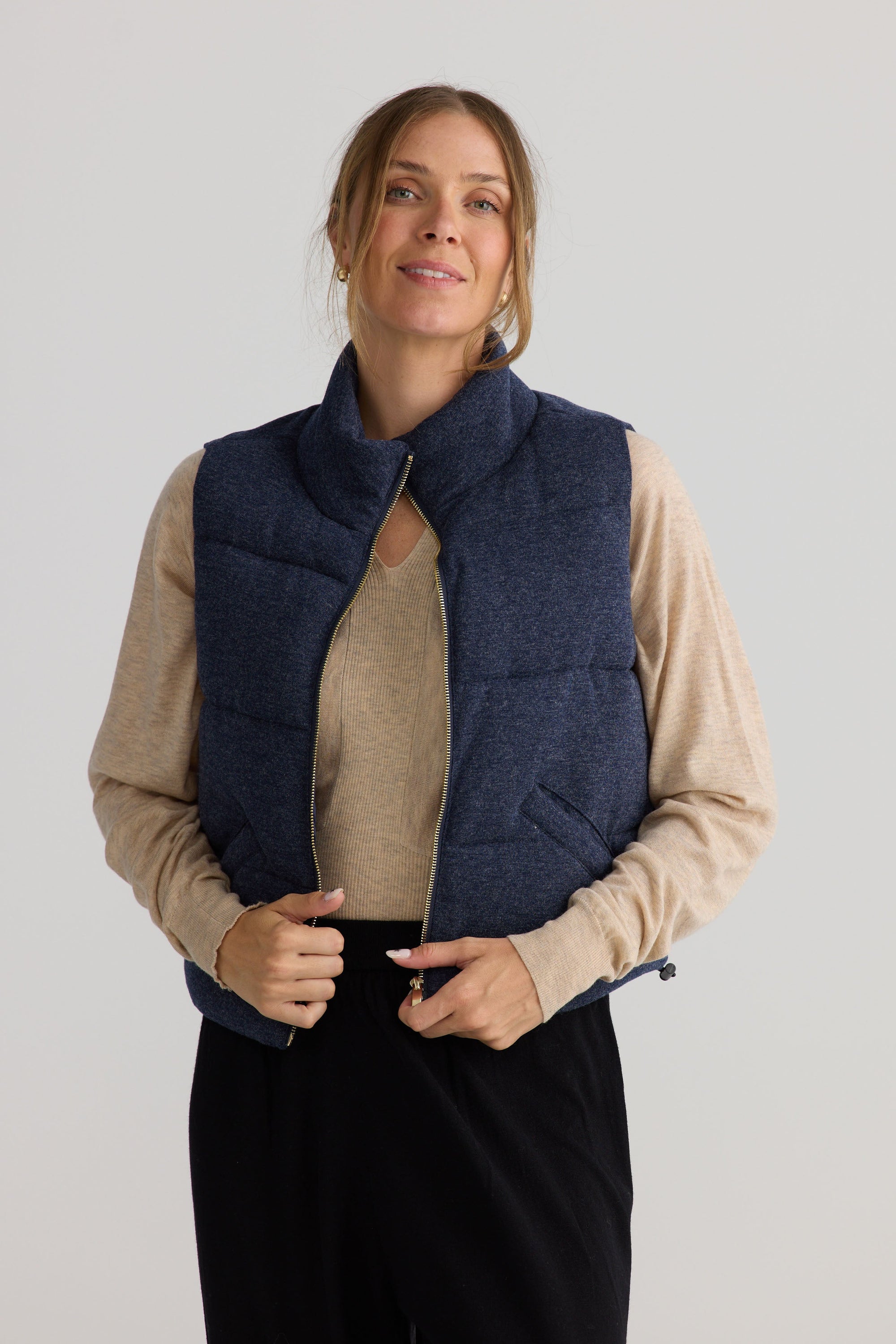 Model wearing Tate Puffer Vest in navy, showing puffer quilting.