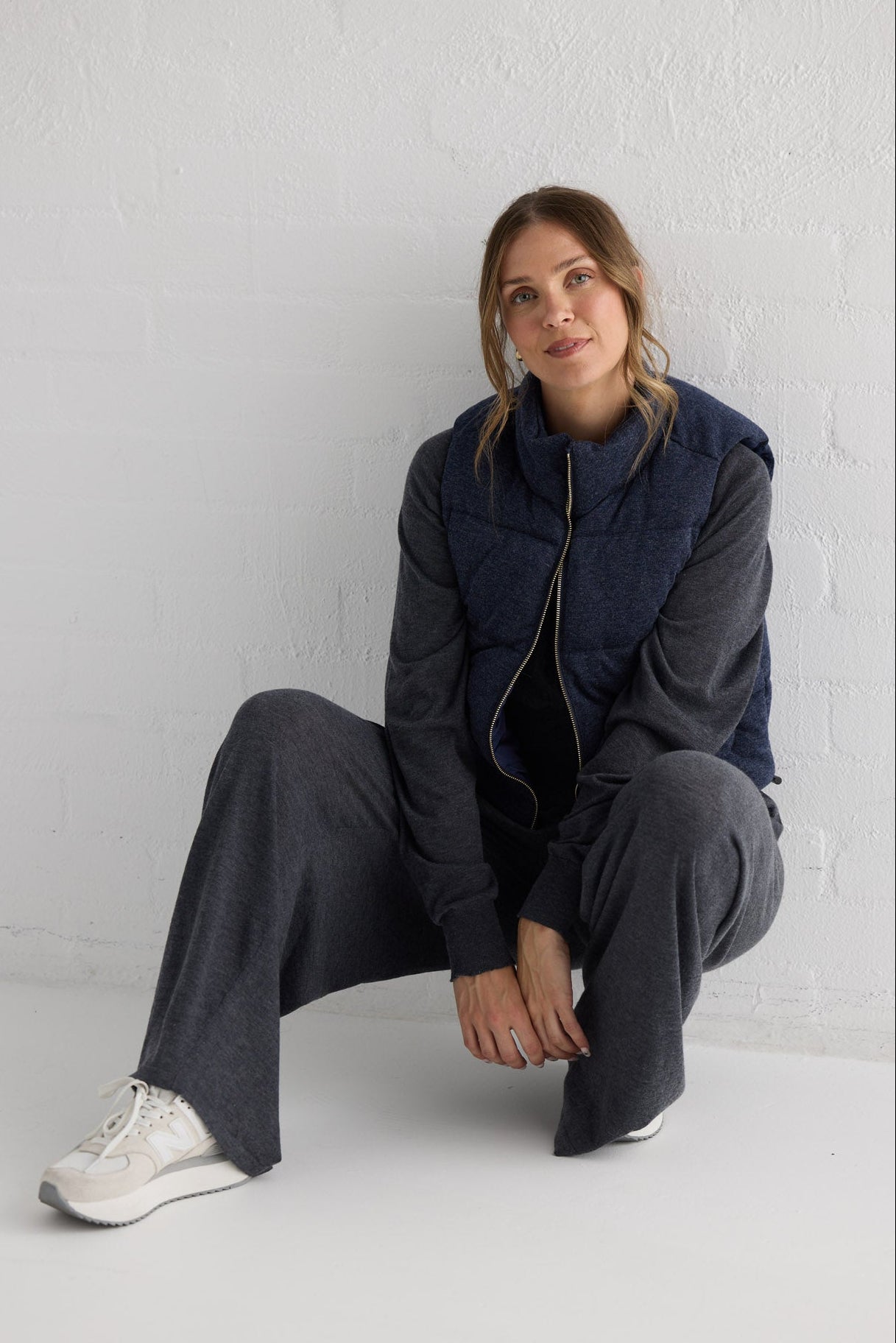 Campaign image of model wearing Tate Puffer Vest in navy.